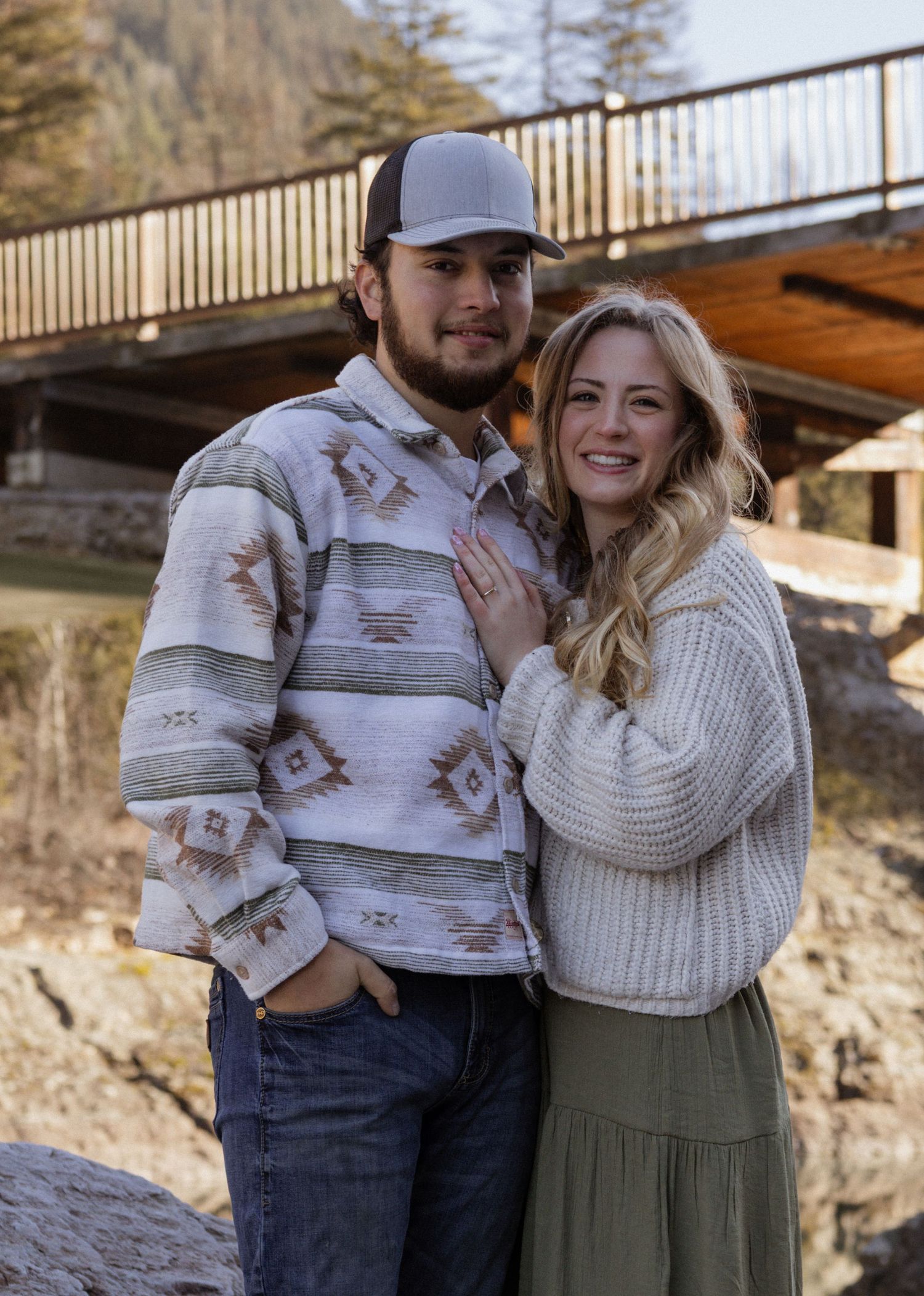 An engaged couple hugging and smiling looking at the camera during a couples session in West Glacier Montana