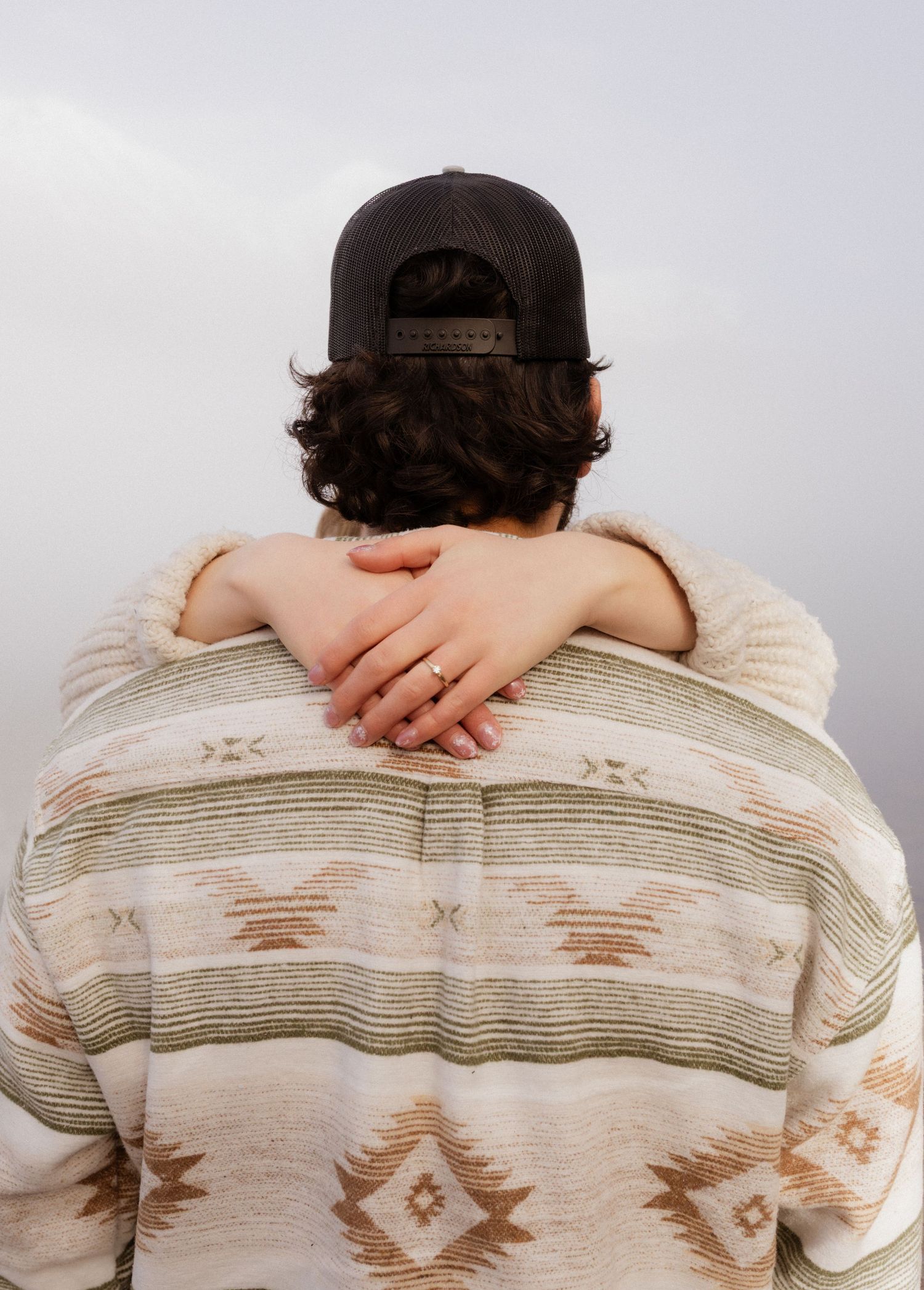 A couple hugging while her hands are around his neck during an engagement session in West Glacier Montana