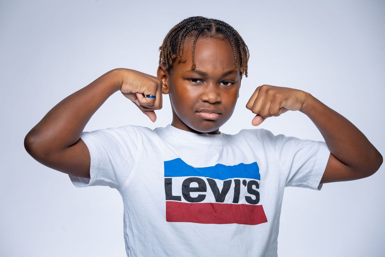 A person in a white Levi's t-shirt poses with raised fists against a light background.