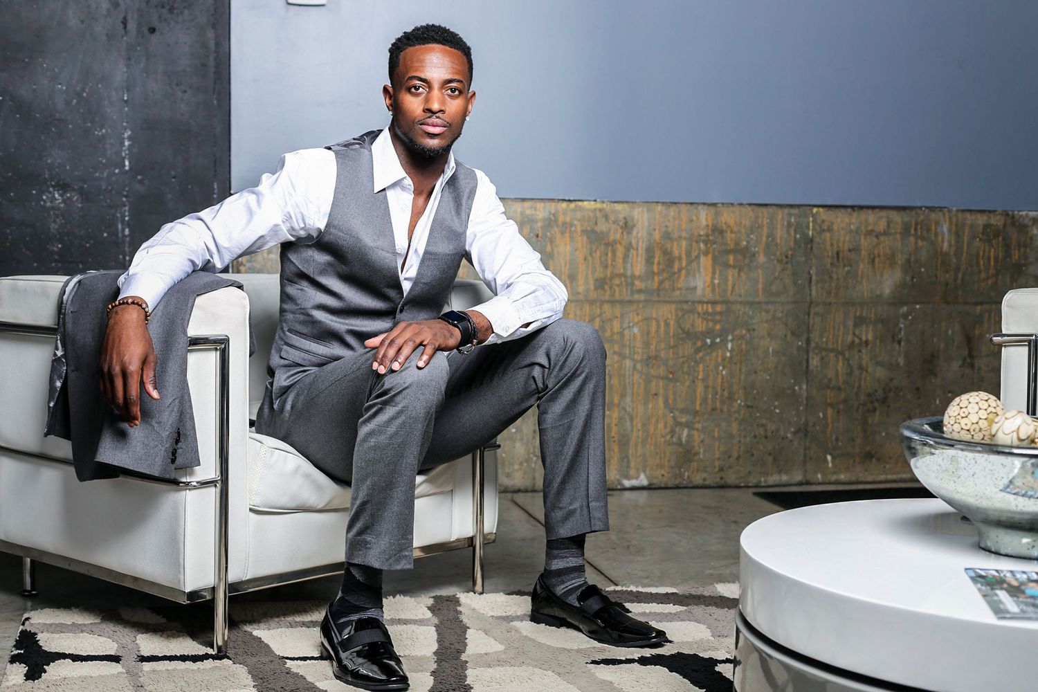 A person in business attire sits in various poses against modern interior backgrounds with clean, minimalist styling.
