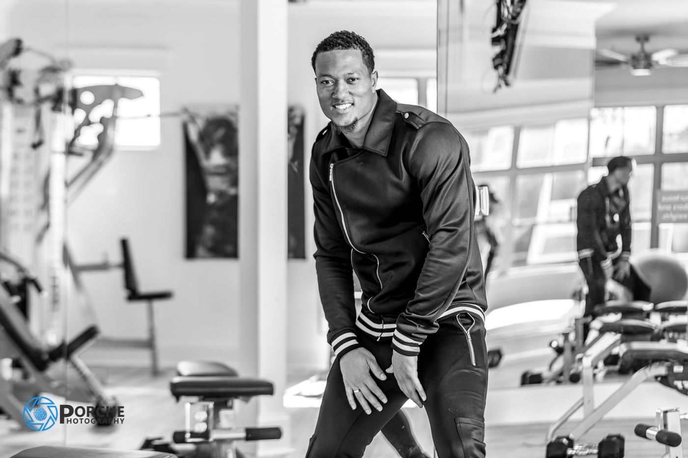 Athletic person working out intensely at a modern gym facility with various exercise equipment in background.
