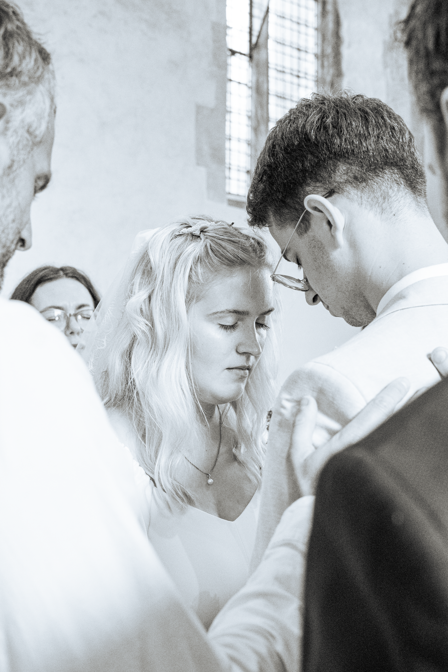 Black and white photo of bride and groom sharing intimate moment during wedding ceremony.
