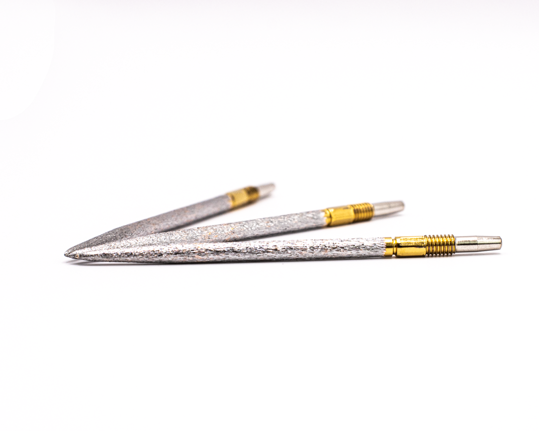 Two silver and gold diamond-tipped engraving stylus pens on white background.