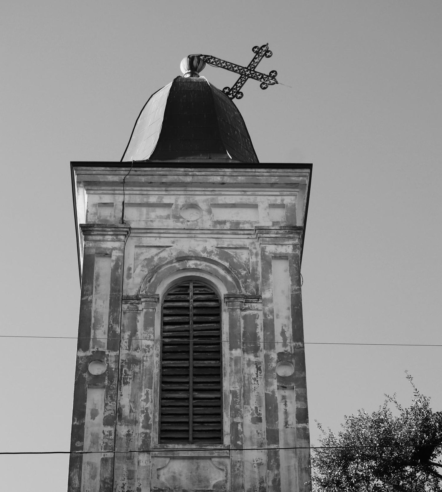 Weathered church tower with a cross in New Orleans Louisiana, showing aged architecture and the passage of time.