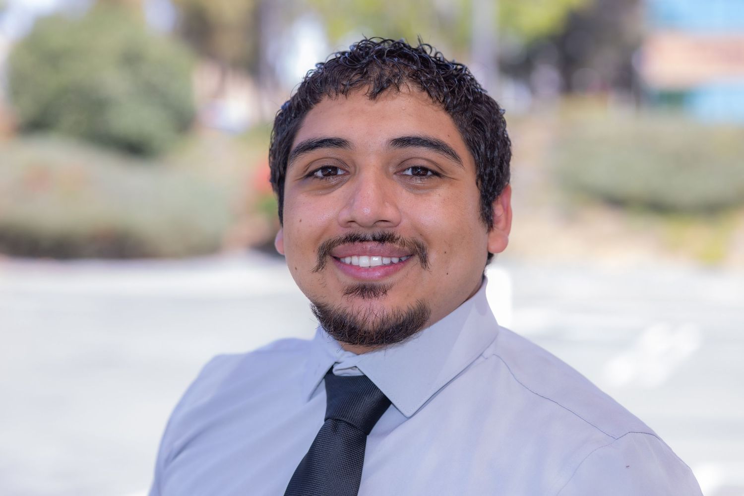 Professional outdoor headshot of a man wearing a dress shirt and tie