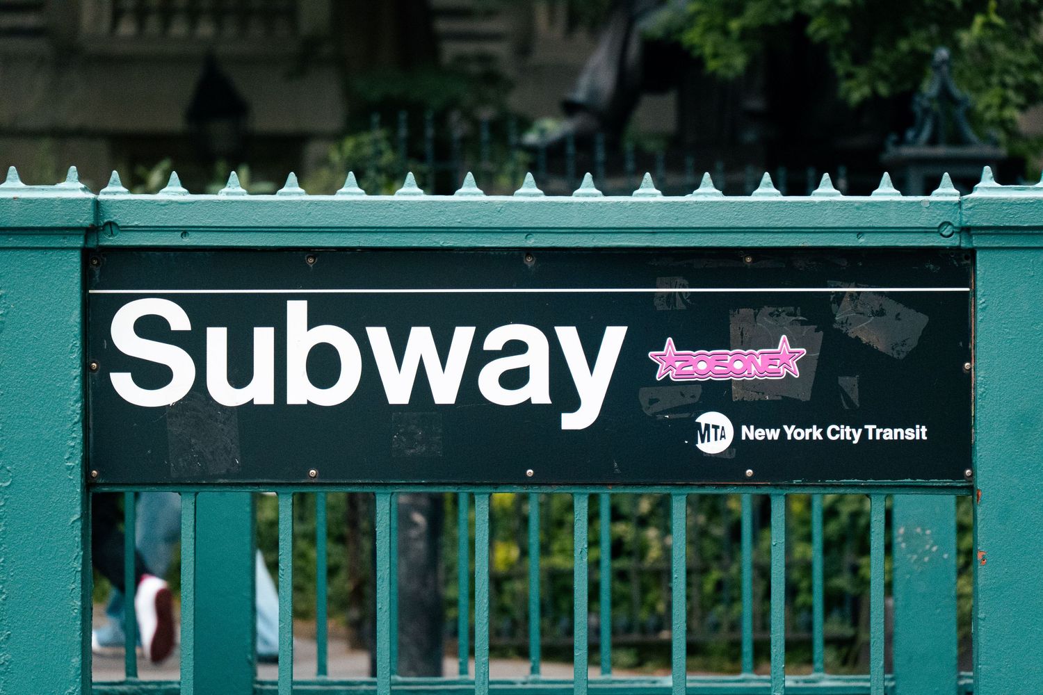 The image depicts a close-up view of a Subway entrance in New York City, with the distinctive Subway logo and signage prominently displayed.