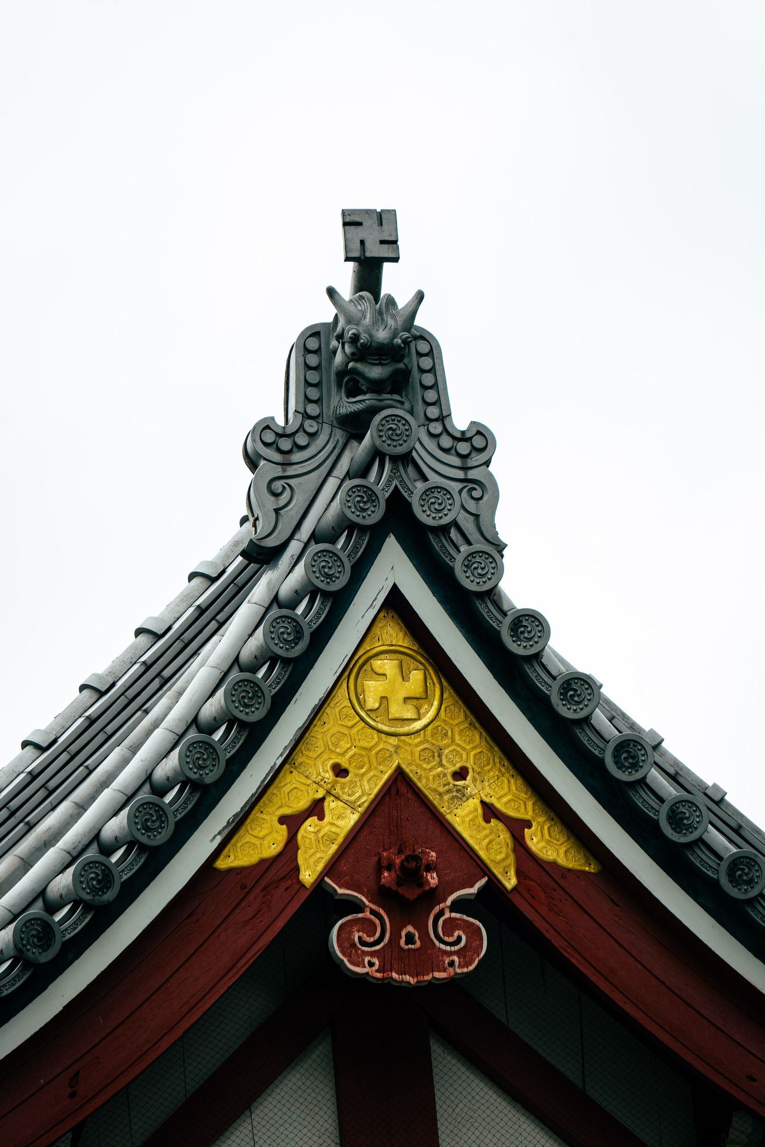An ornate, traditional Japanese roof structure with intricate designs and a golden clock face.