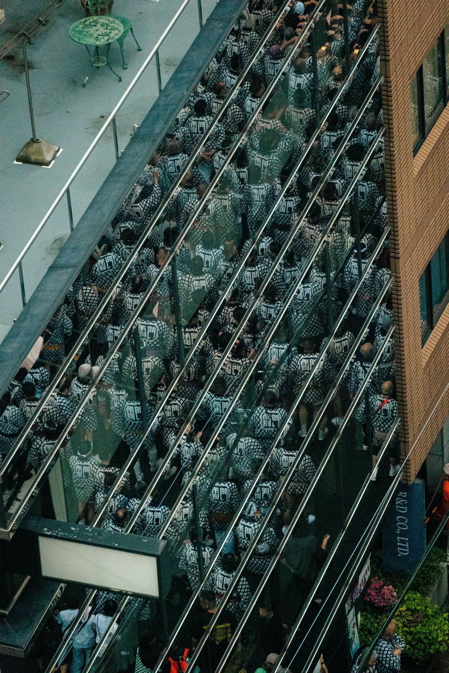 An aerial view of a crowded city street filled with a large gathering of people, with a prominent structure or float in the center.
