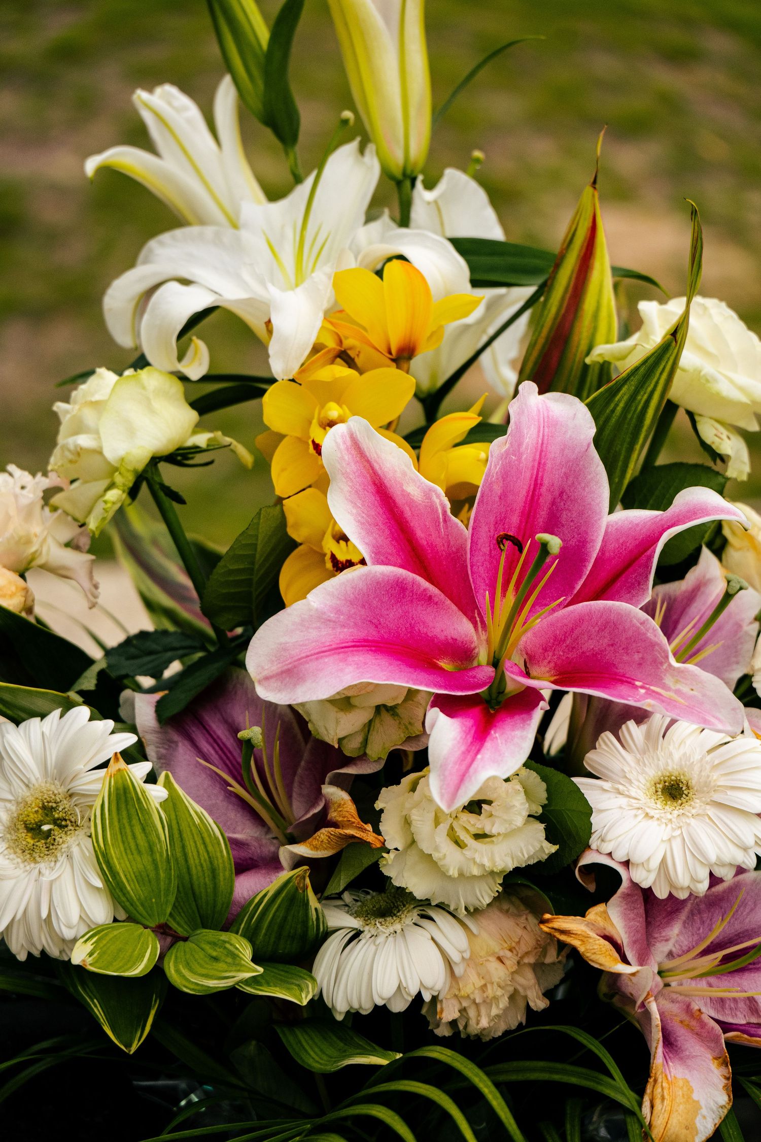 A vibrant bouquet of various flowers including lilies, daisies, and other colorful blooms.