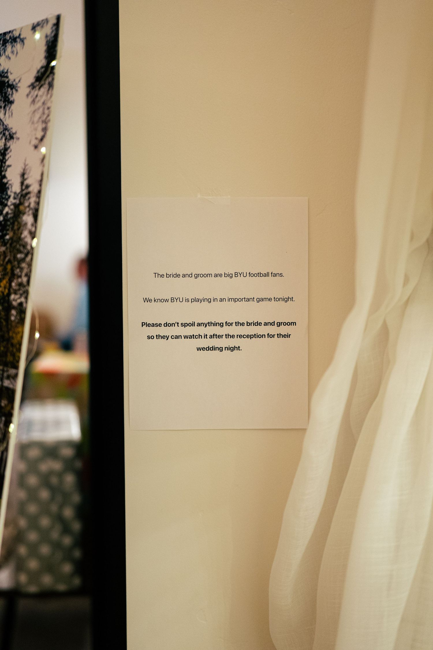 Wedding sign asking guests not to spoil BYU football game for bride and groom on wedding night.