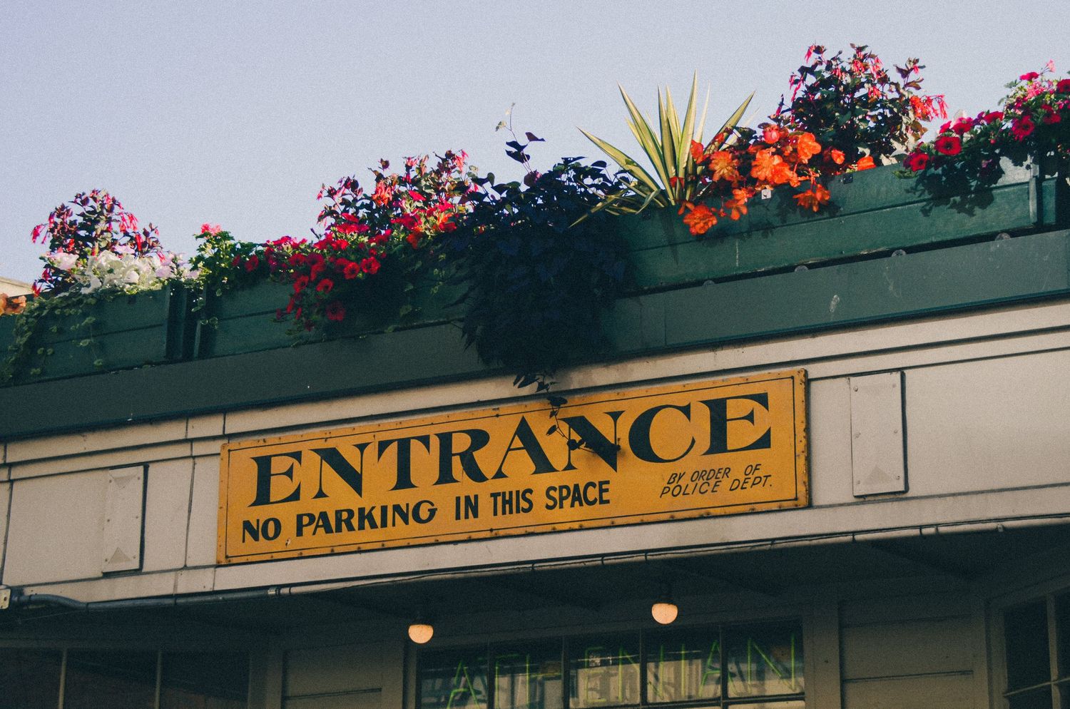 A sign reading 'ENTRANCE NO PARKING IN REAR AREA' is displayed on a building.