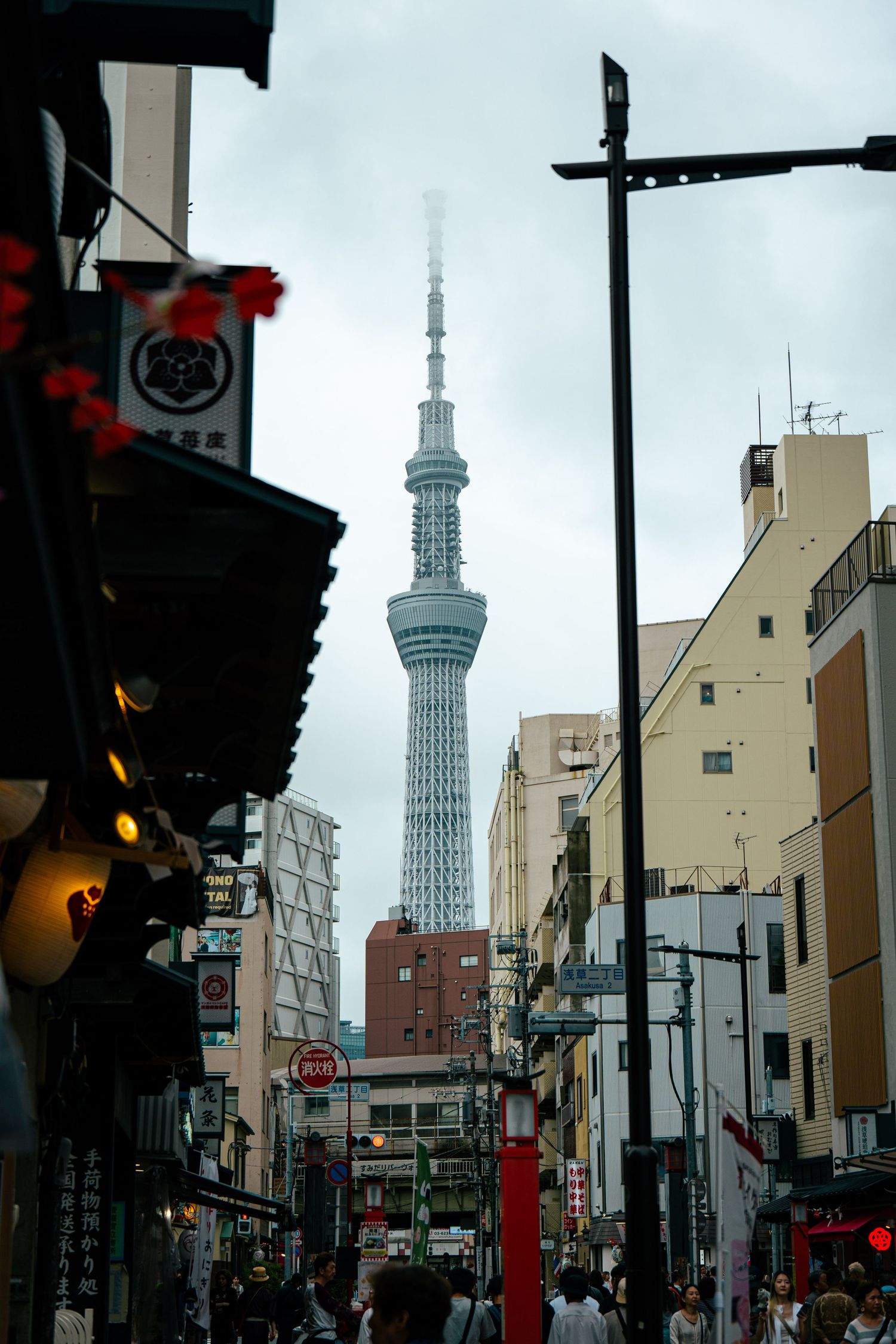 A bustling street scene in Japan, with a large crowd of people gathered around a festival float adorned with lanterns.