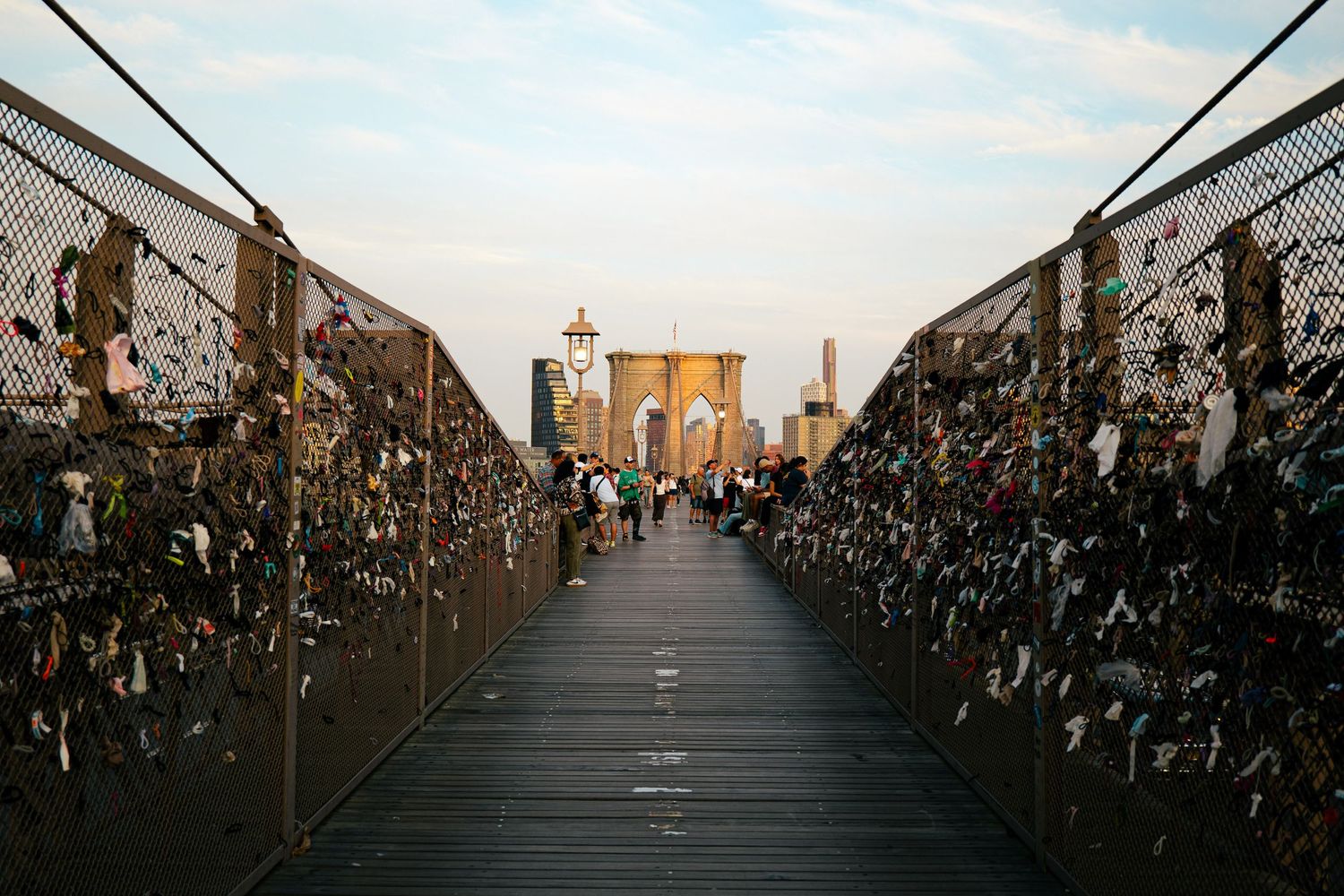 A wooden walkway leading to the Manhattan skyline, with the Brooklyn Bridge visible in the background.