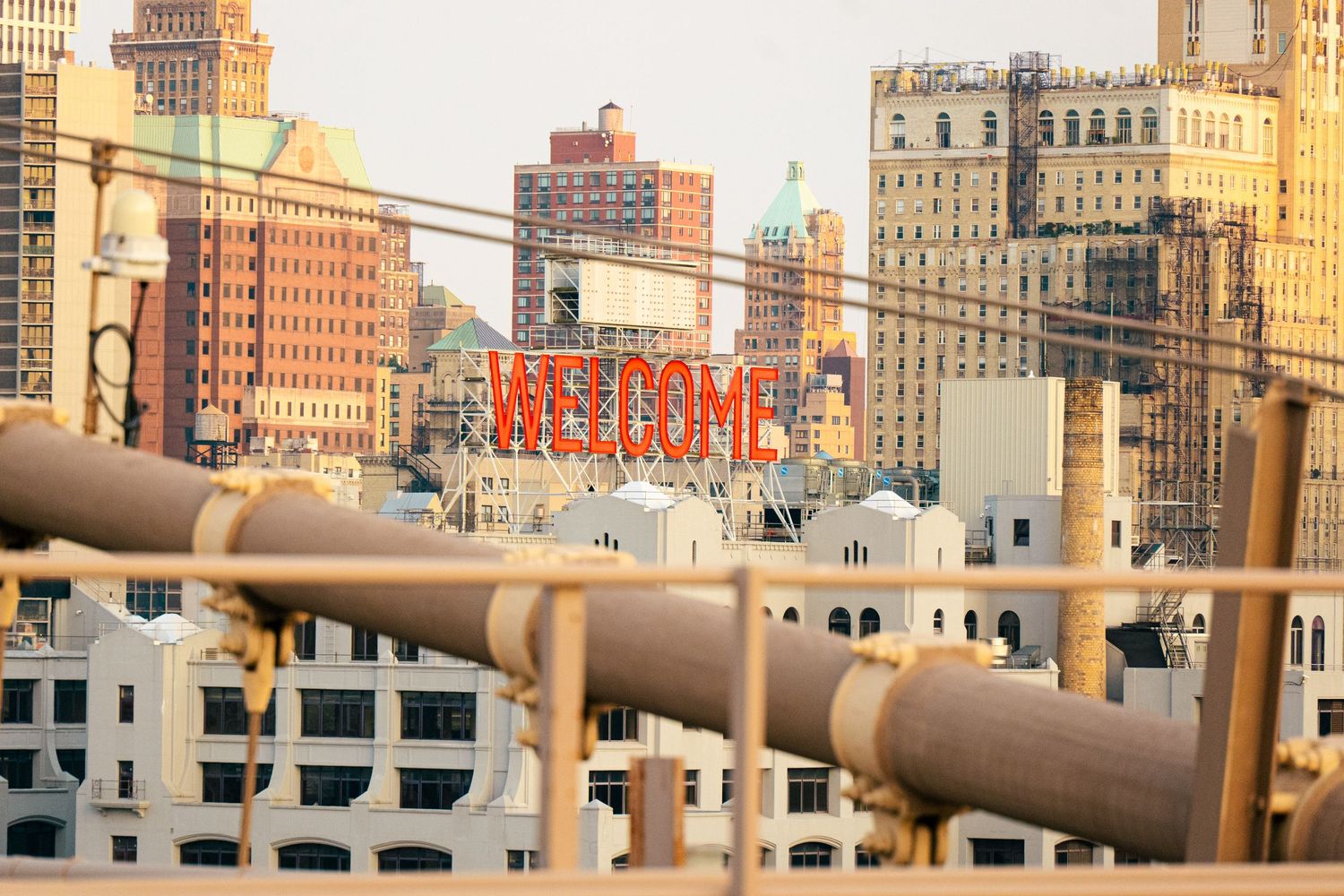 A cityscape with tall buildings, including a large sign that says 'Welcome', viewed from a high vantage point.