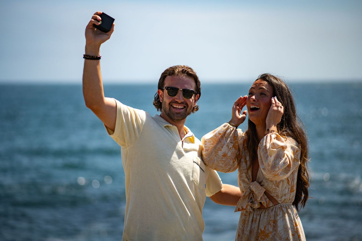 Couple taking selfie after beach proposal.