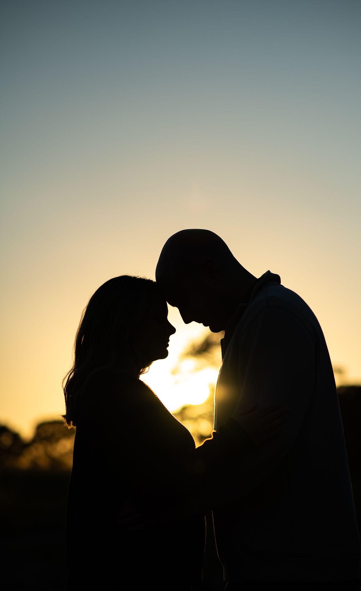 Couple silhouette portrait at sunset during an engagement session.