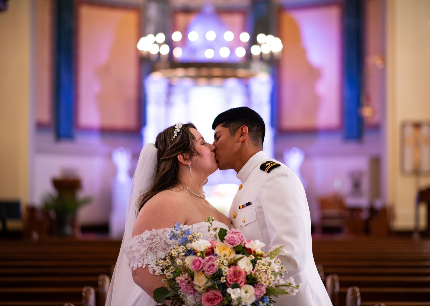 Bride and groom kissing in church after wedding ceremony.