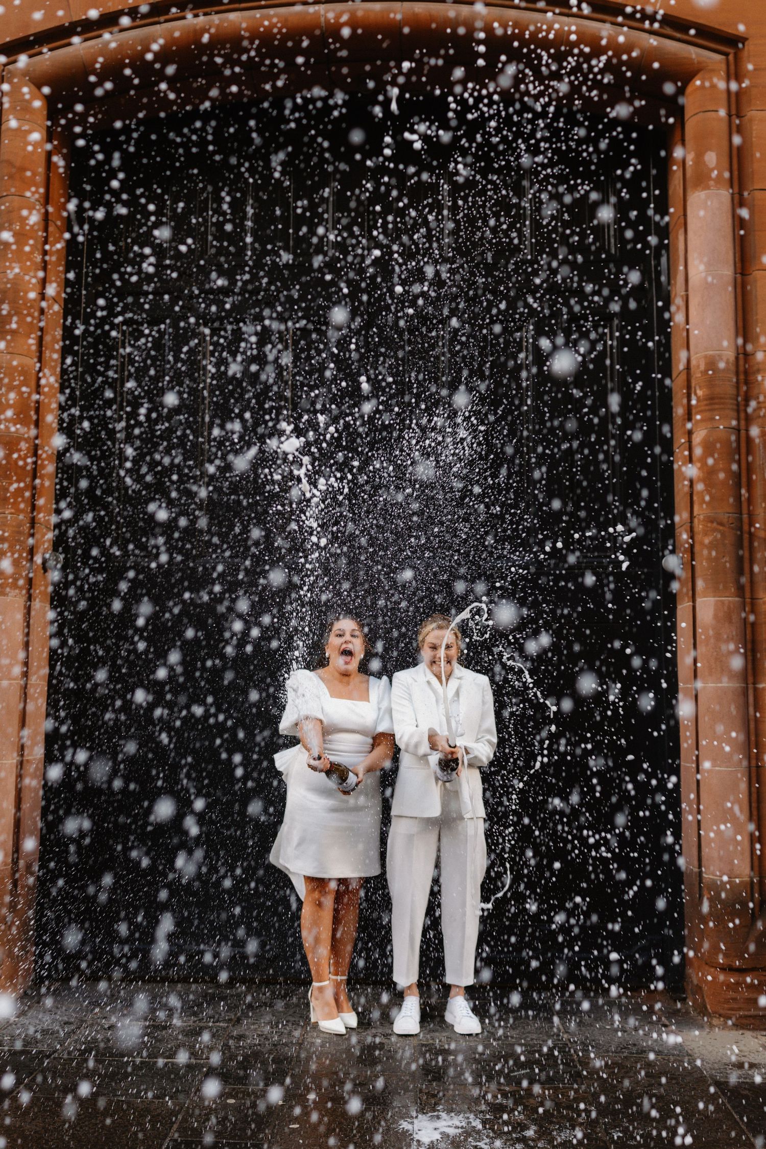 A winter wedding scene with falling snow against a dark background.