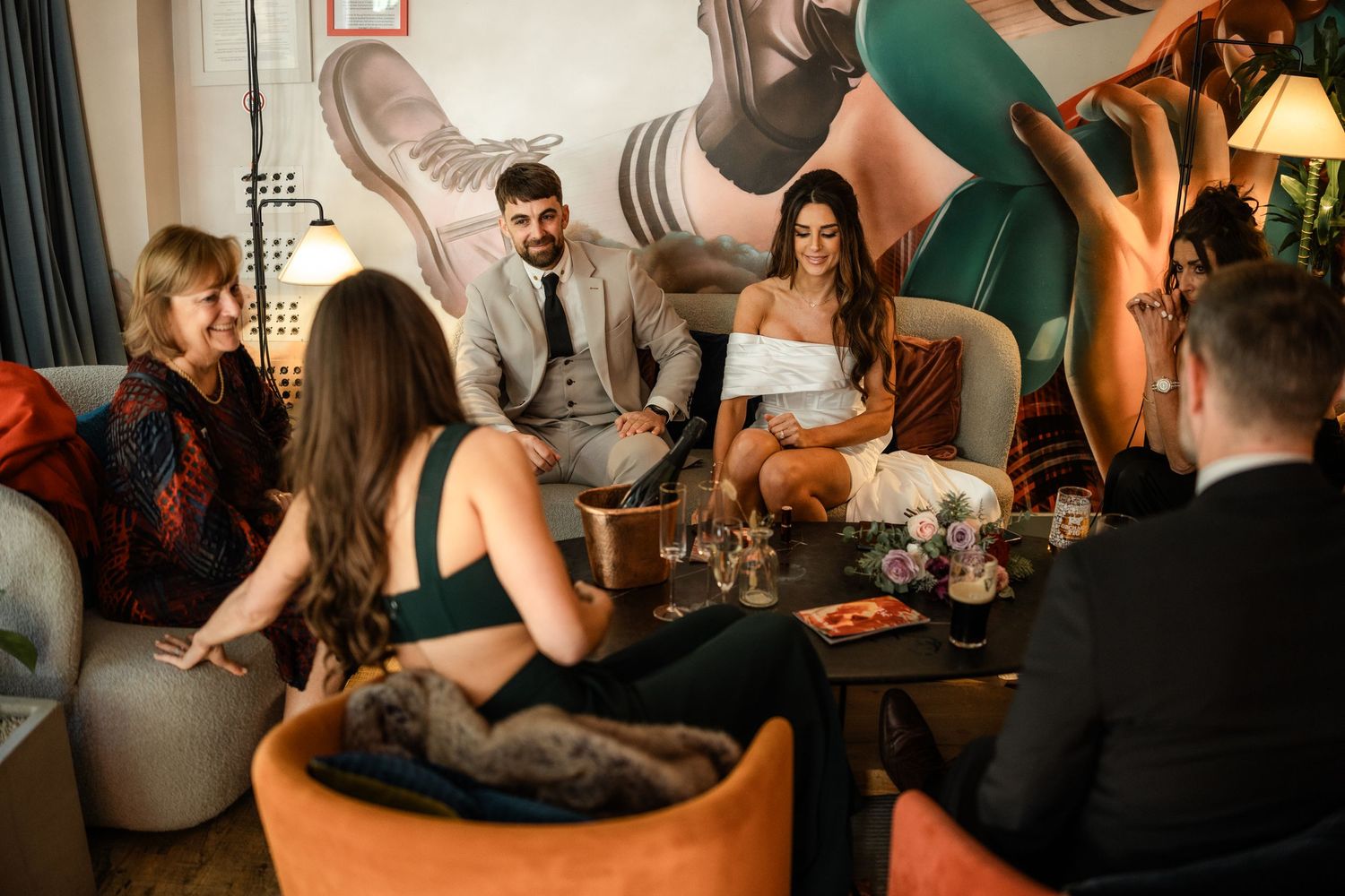 People enjoying drinks and conversation at a dimly lit bar or restaurant.
