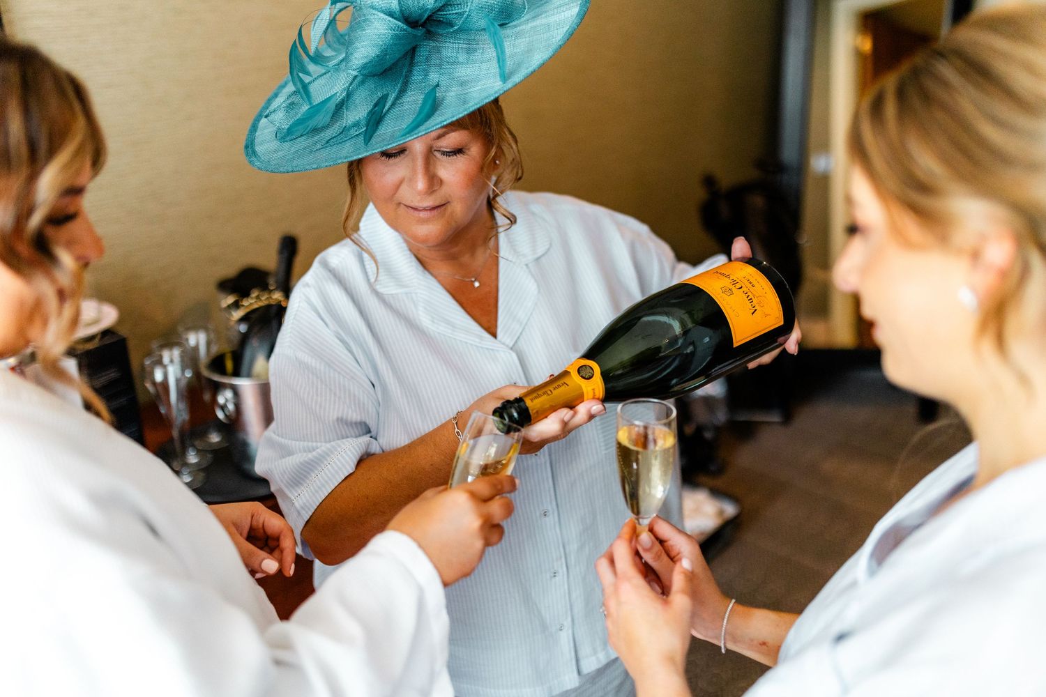 Mother of the Bride holding a champagne, pouring glasses, wedding Glass House Edinburgh, Scotland,