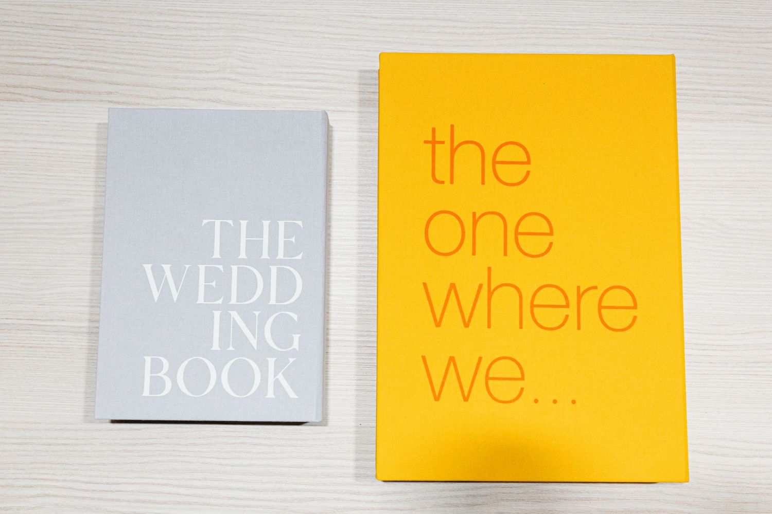 Two wedding-themed books side by side, one gray titled 'The Wedding Book' and one yellow titled 'the one where we...'.