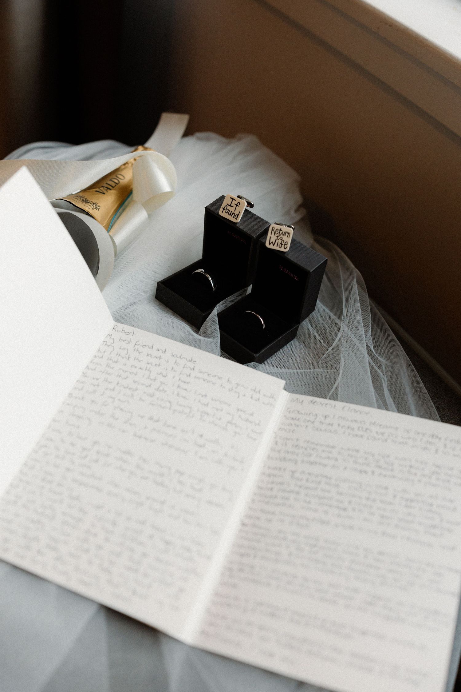 A handwritten letter lies next to a veil on a white surface.