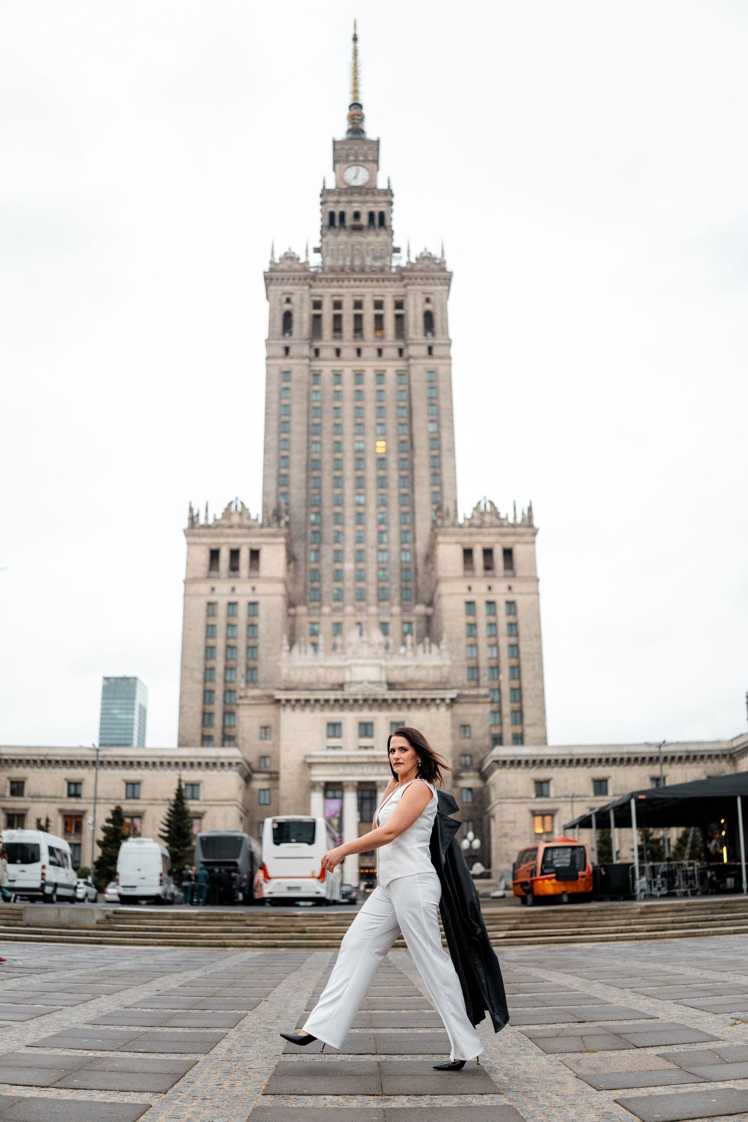 Artistic wedding photo series in front of the Palace of Culture and Science in Warsaw featuring flowing white dress.