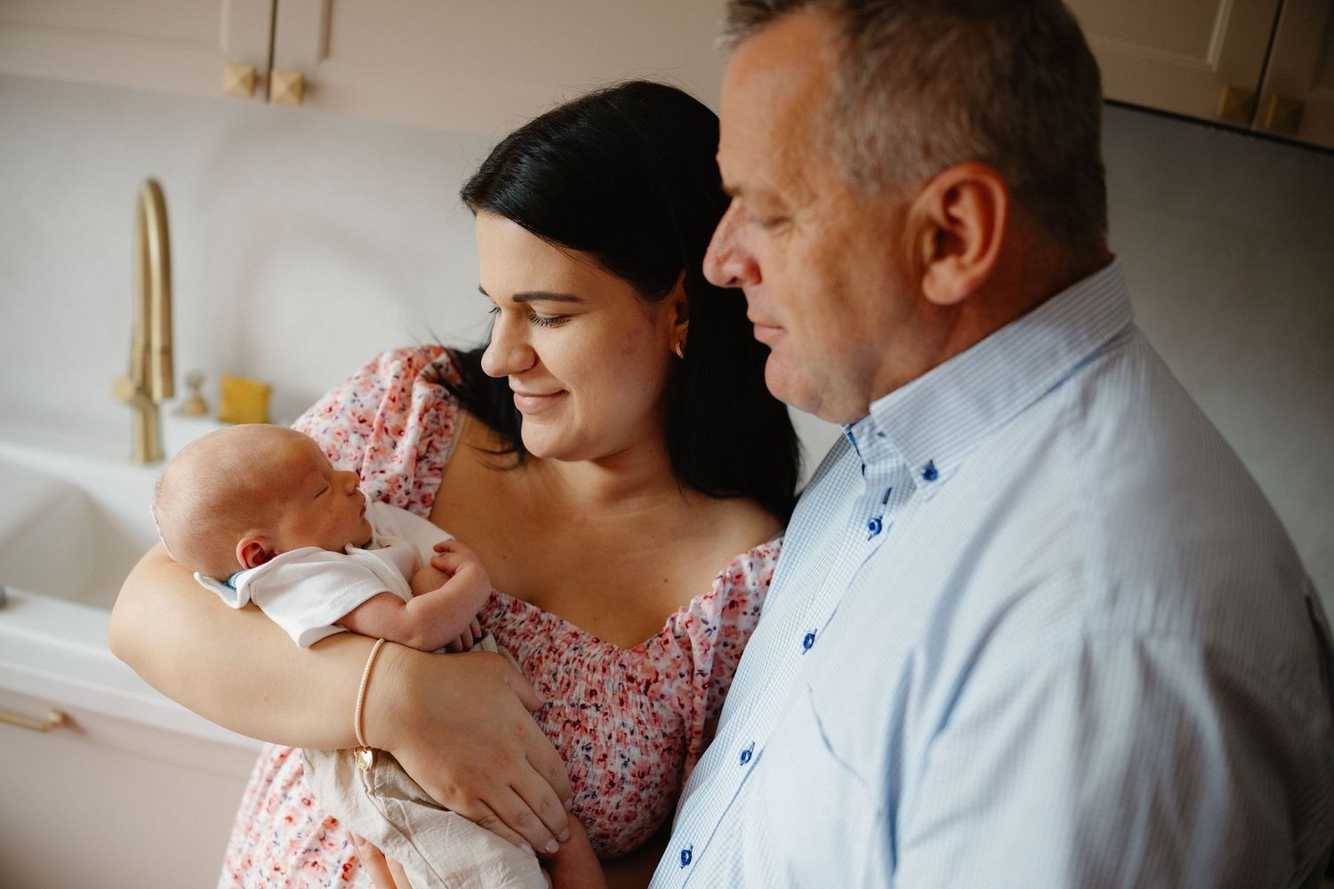 Family sharing gentle moments with their newborn in natural lighting.