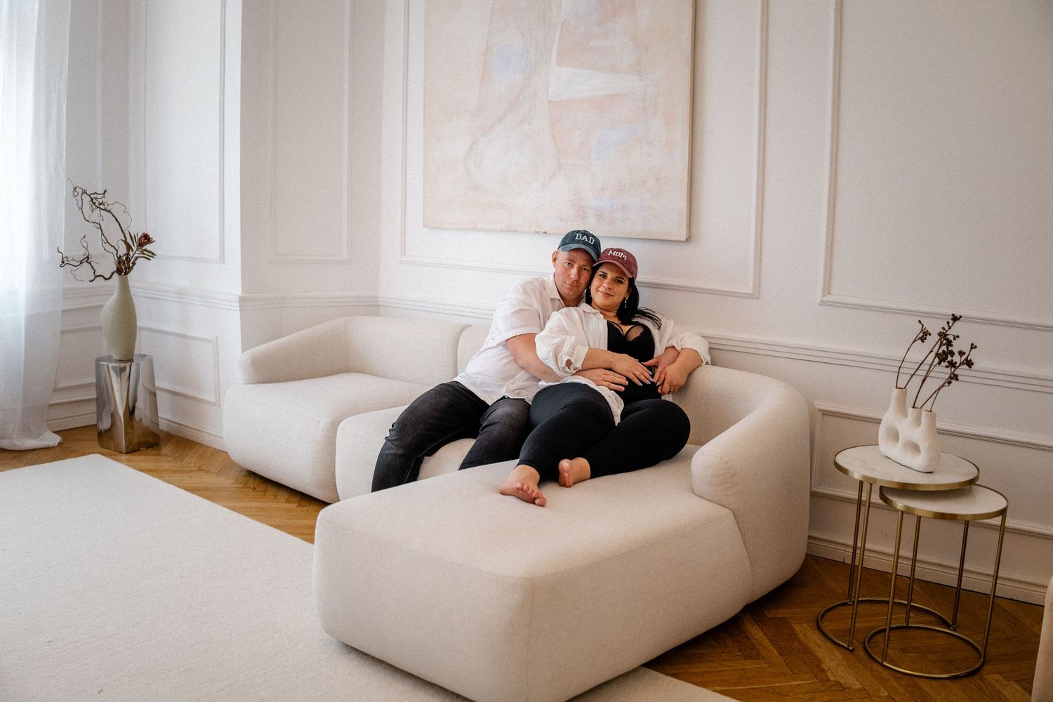 Wide angle view of a modern white room with people lounging on contemporary furniture.