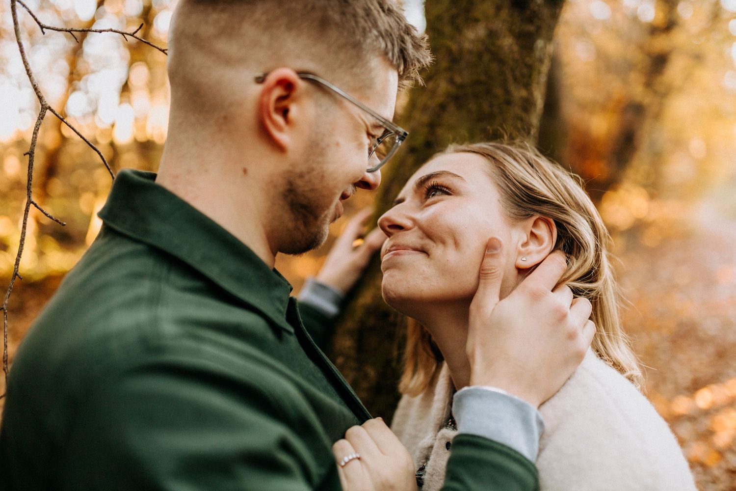 Romantic autumn photoshoot with golden sunlight filtering through trees.