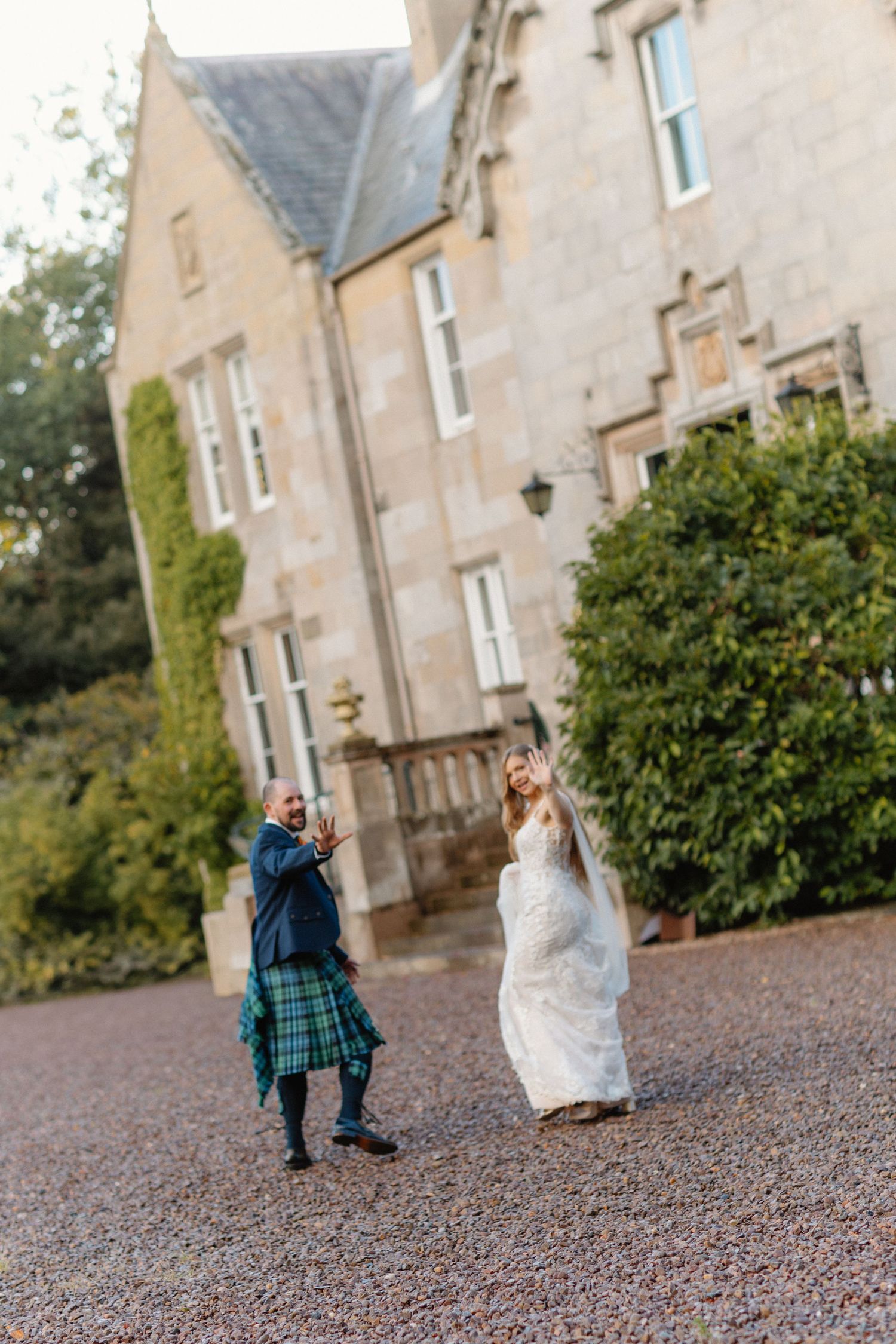 A playful wedding photoshoot in front of a stone building with running poses.