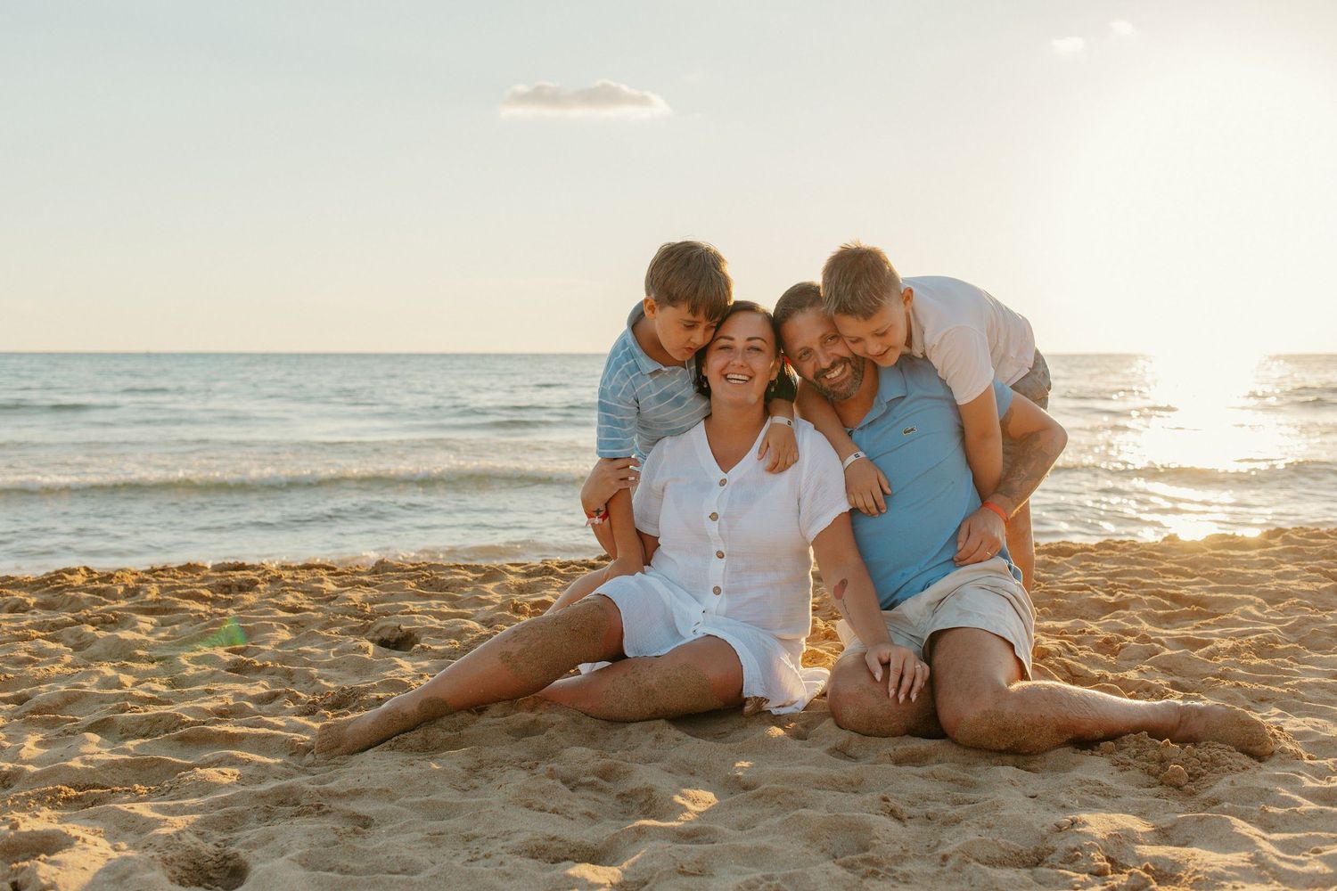 A couple shares intimate moments on a sandy beach at sunset.