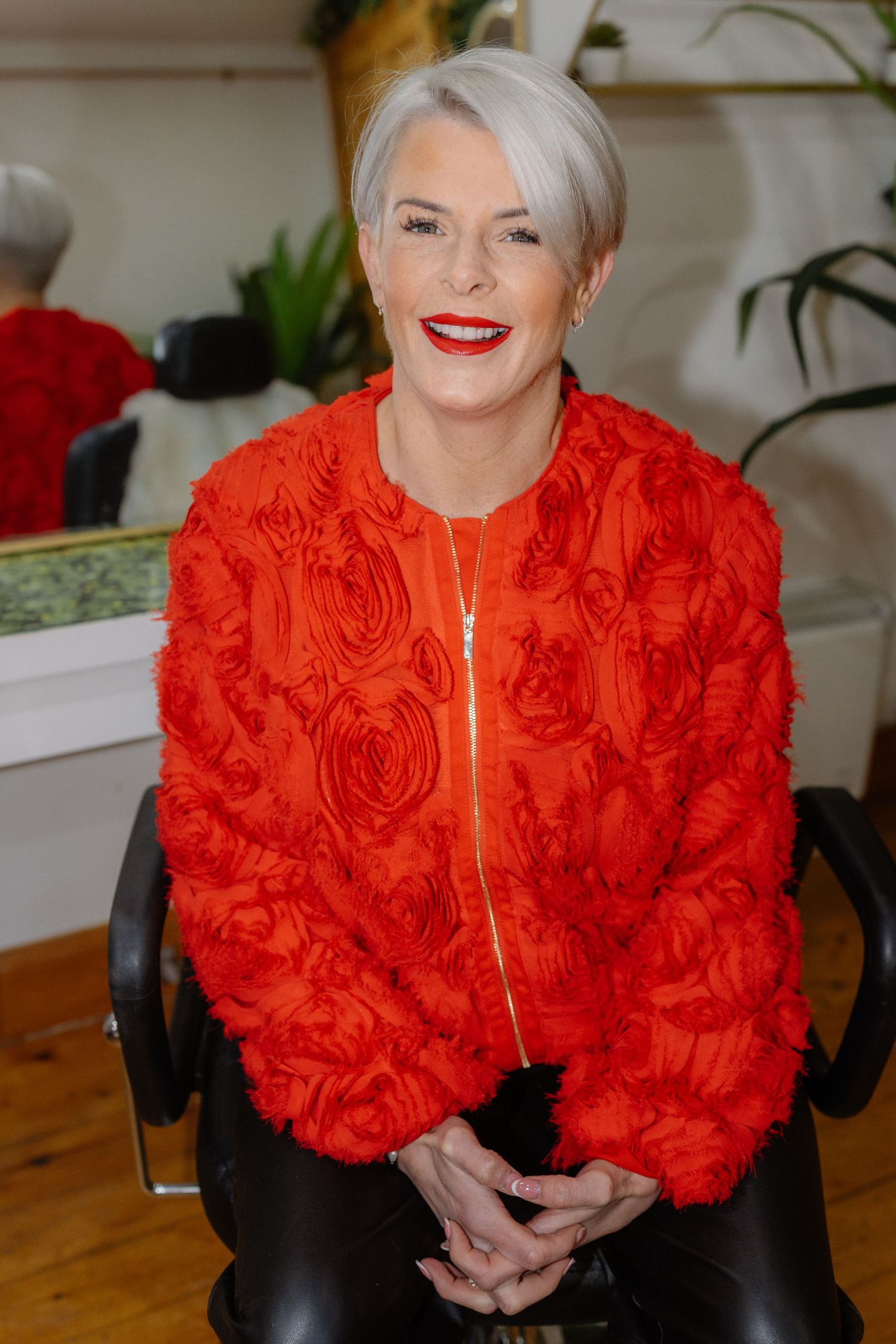 A person wearing a vibrant red ruffled shawl and black outfit poses in a sequence of similar photos.