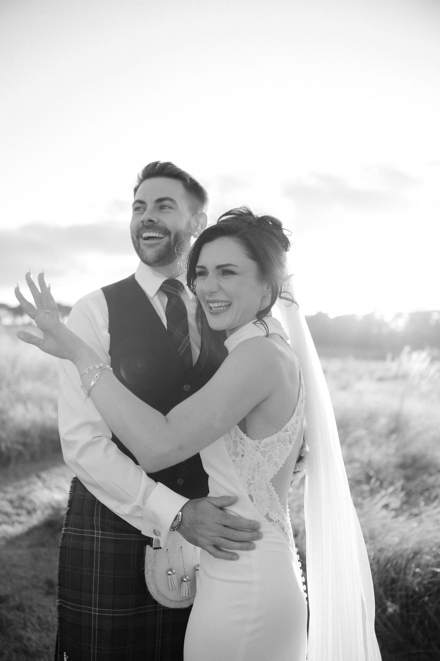 Joyful black and white portraits of couple laughing and embracing outdoors.