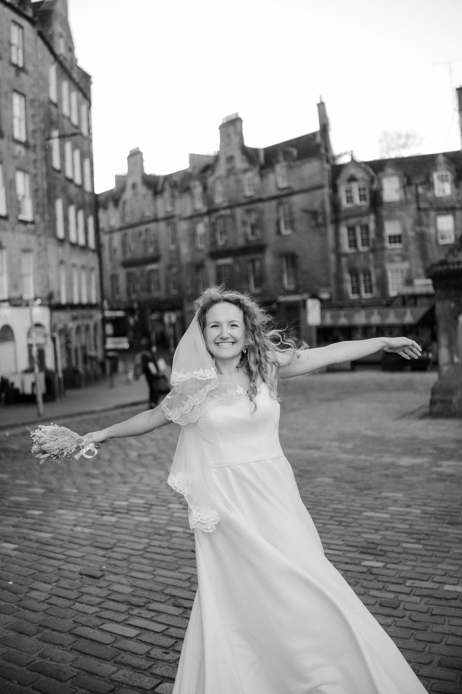 A joyful moment on cobblestone streets with historic buildings in the background.