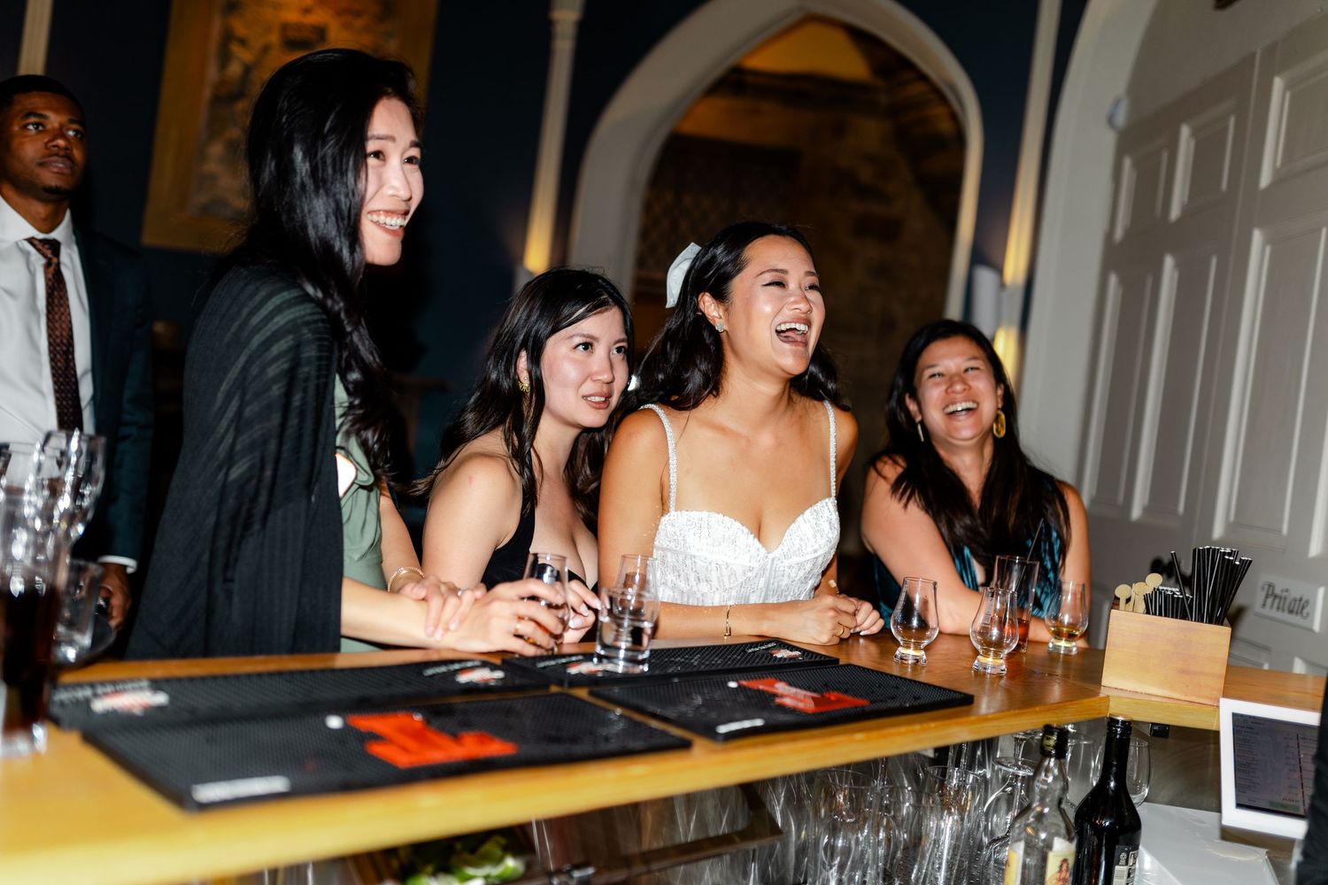 Guests socializing at an elegant bar during an evening wedding reception.