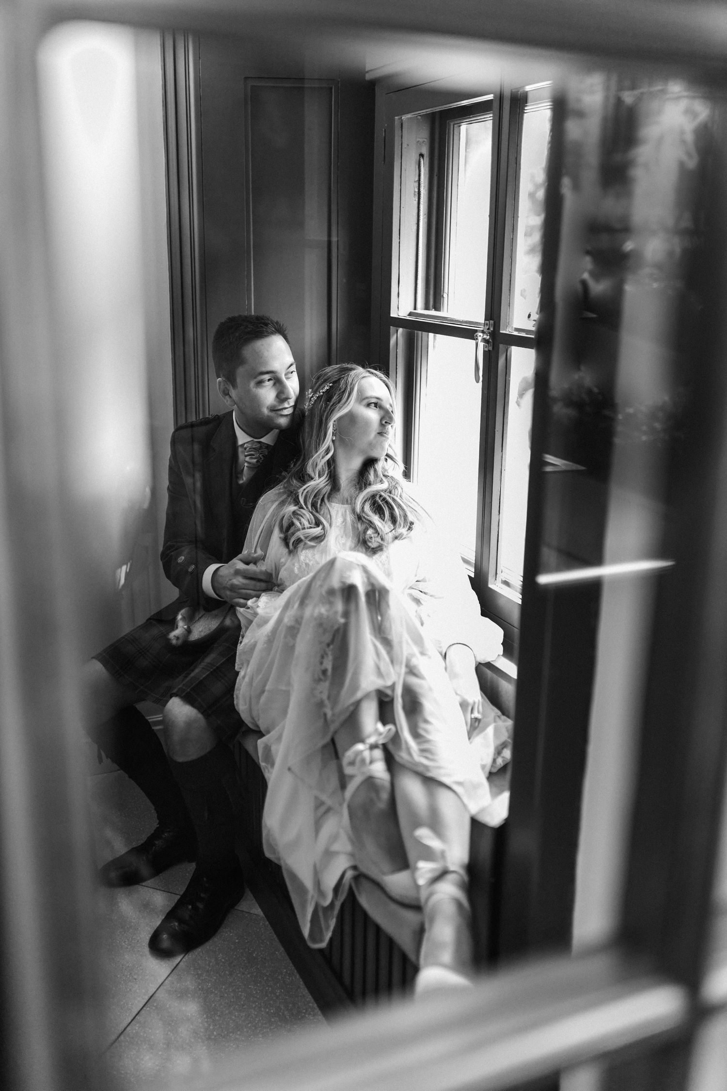Artistic black and white sequence captured through window panes showing movement and dance.