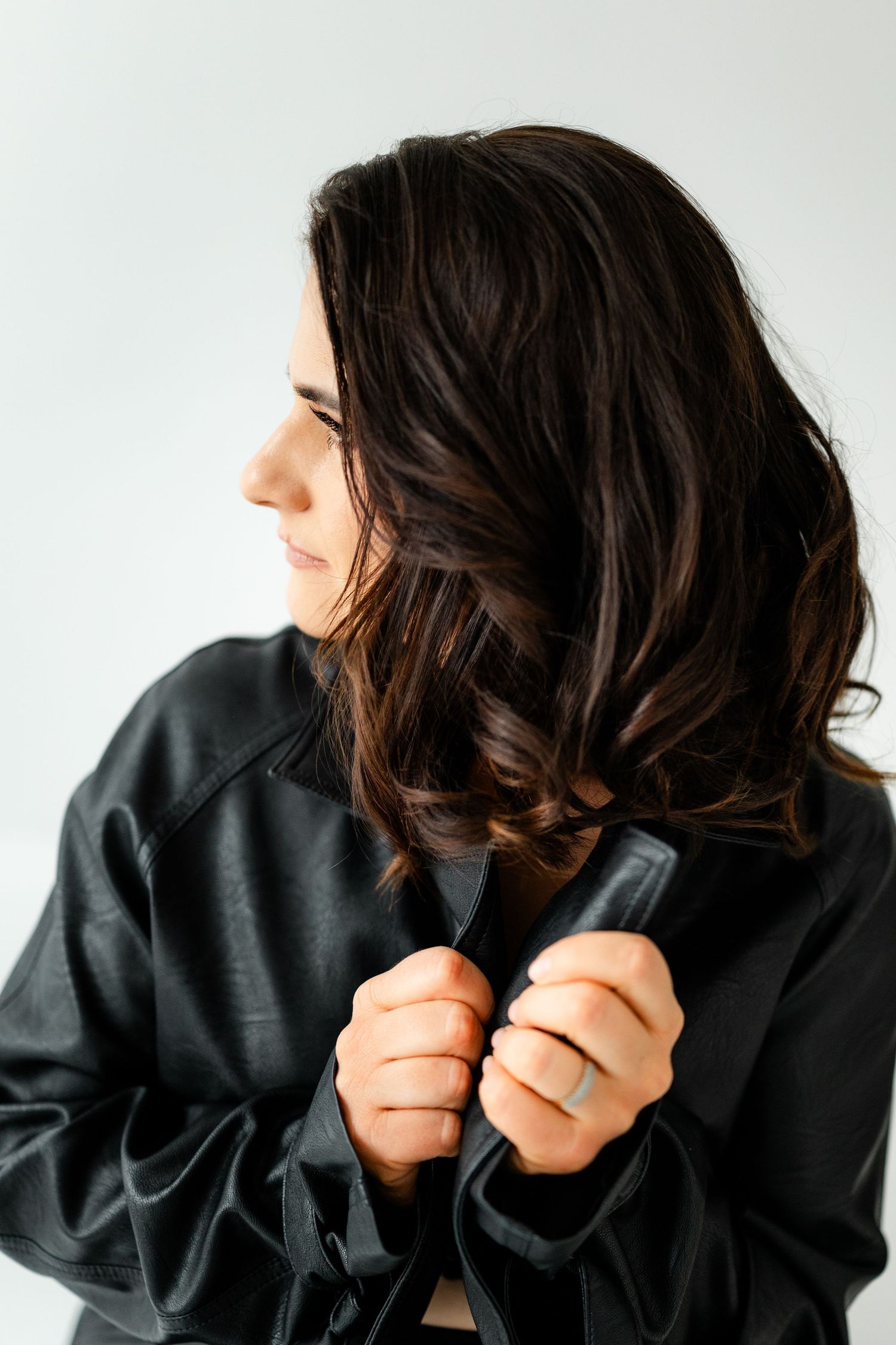 Artistic portrait series showing dark hair against white background in dramatic lighting.