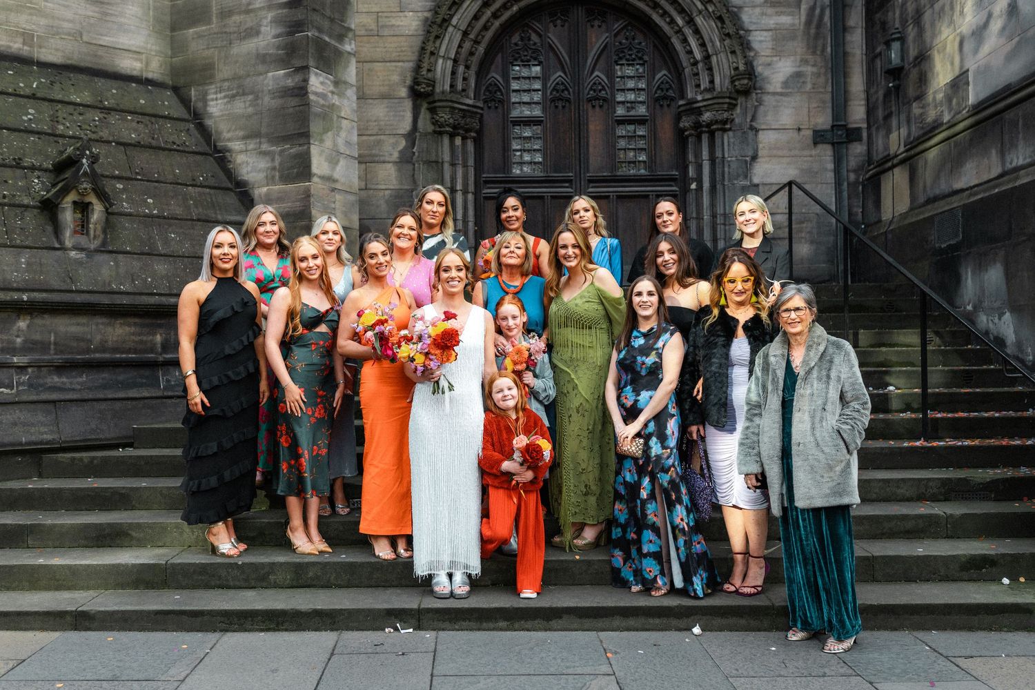 Wedding party members arranged in different group formations on historic stone steps.