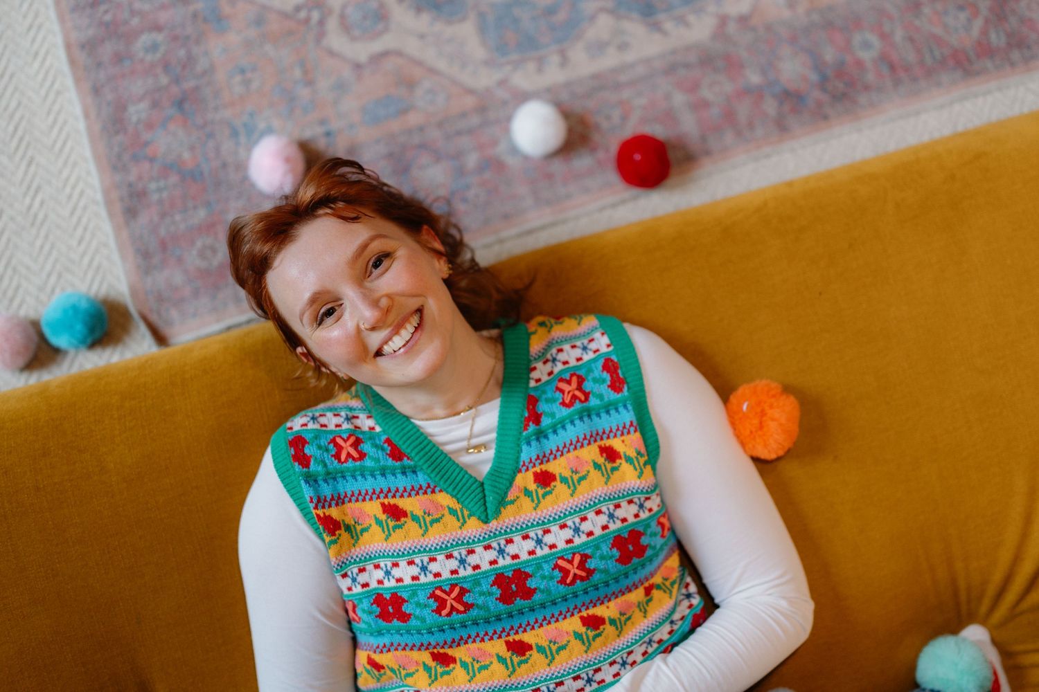 Joyful moments captured on a yellow couch with floating pom poms.