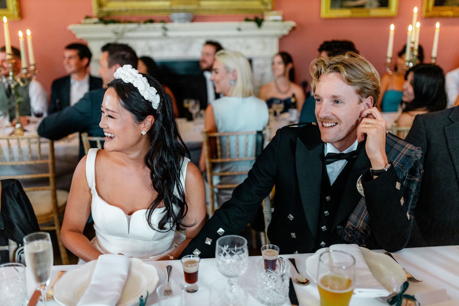 Wedding reception guests sharing animated conversations in an elegantly decorated dining room.