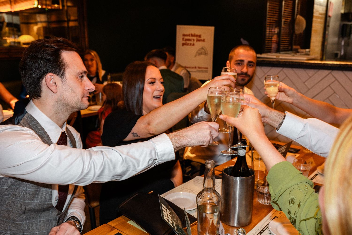 Wedding guests toasting and celebrating at a lively reception party.