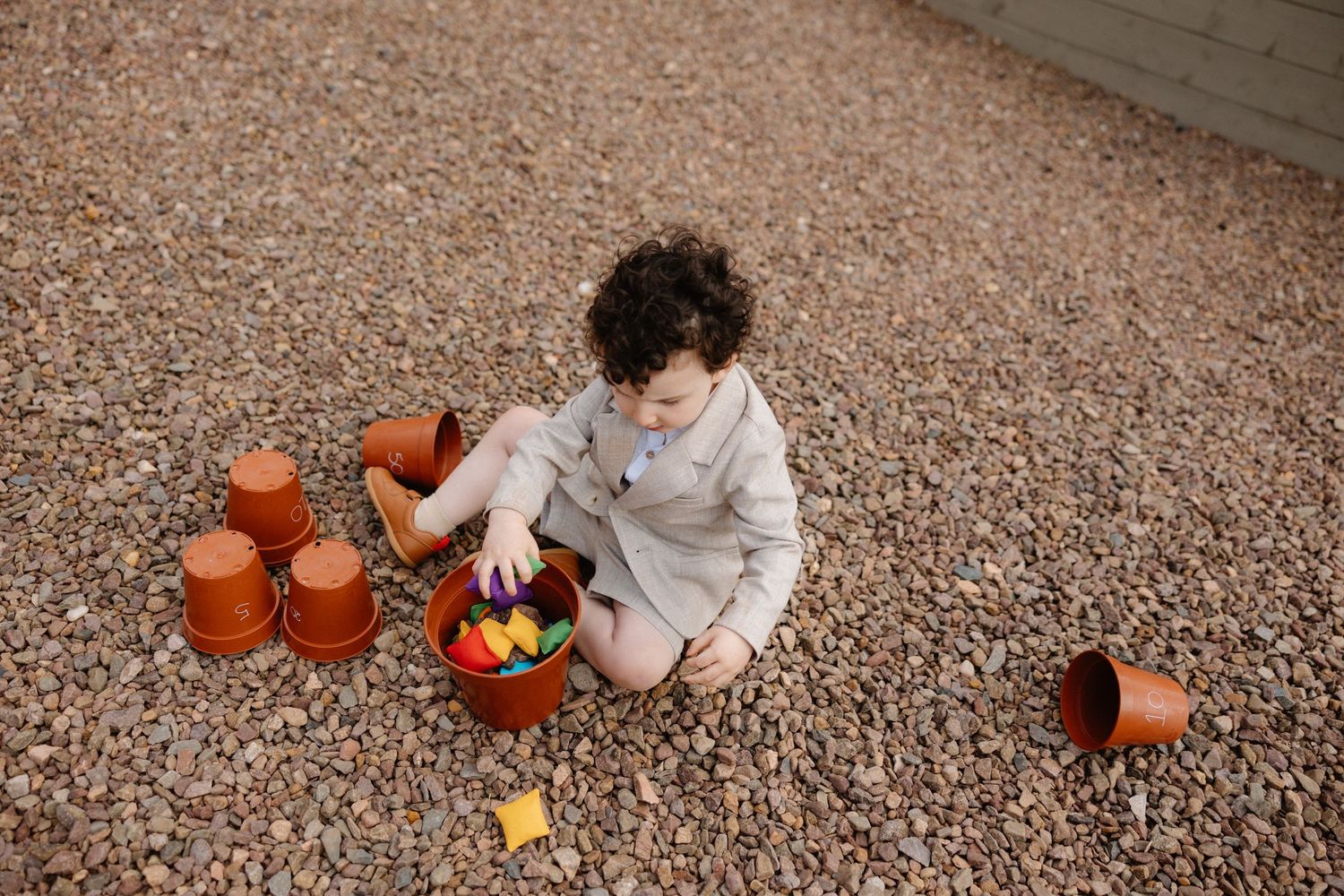 Scattered pumpkins and decorative gourds on gravel create a rustic autumn display.