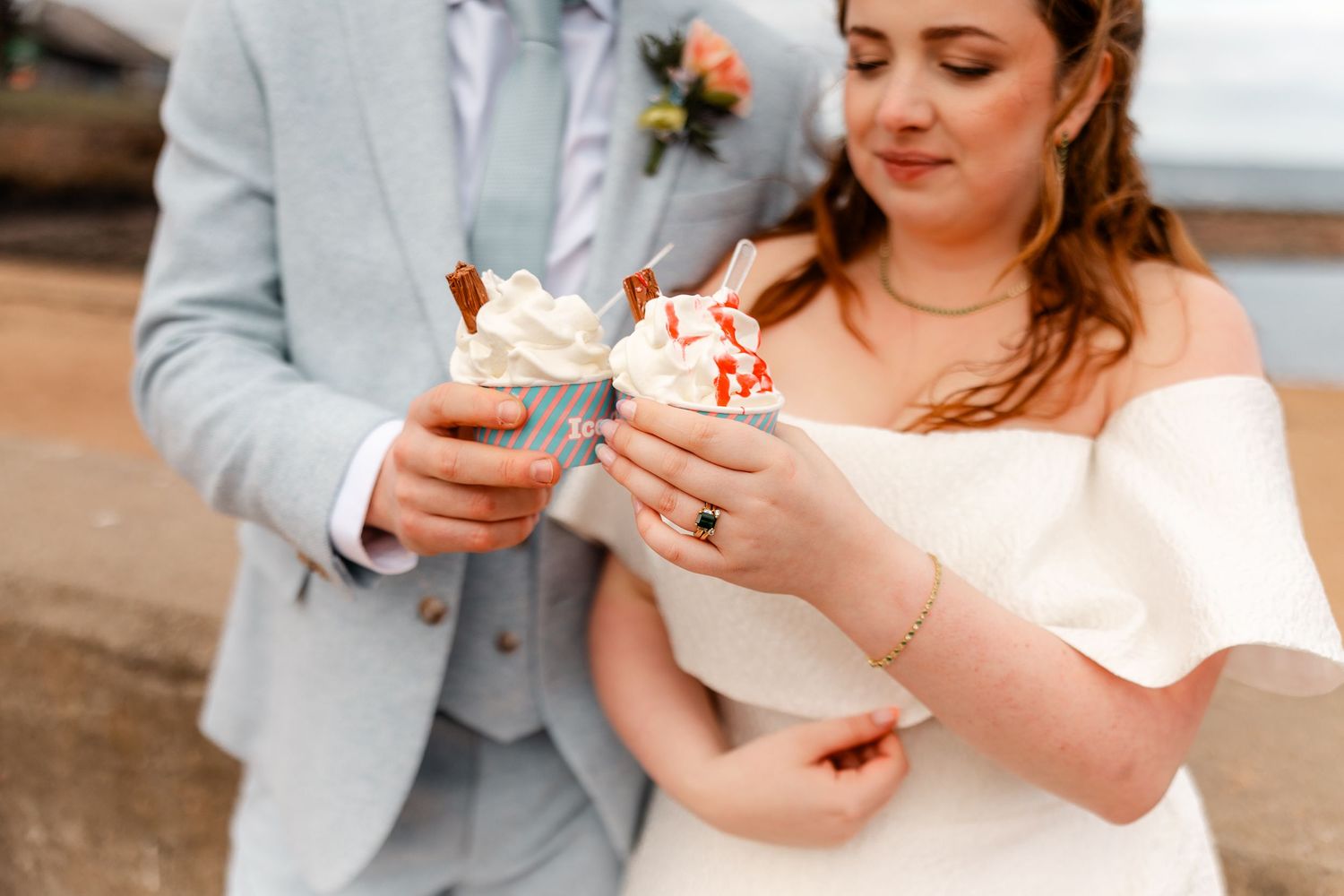A couple in wedding attire shares slices of pie during their outdoor celebration.
