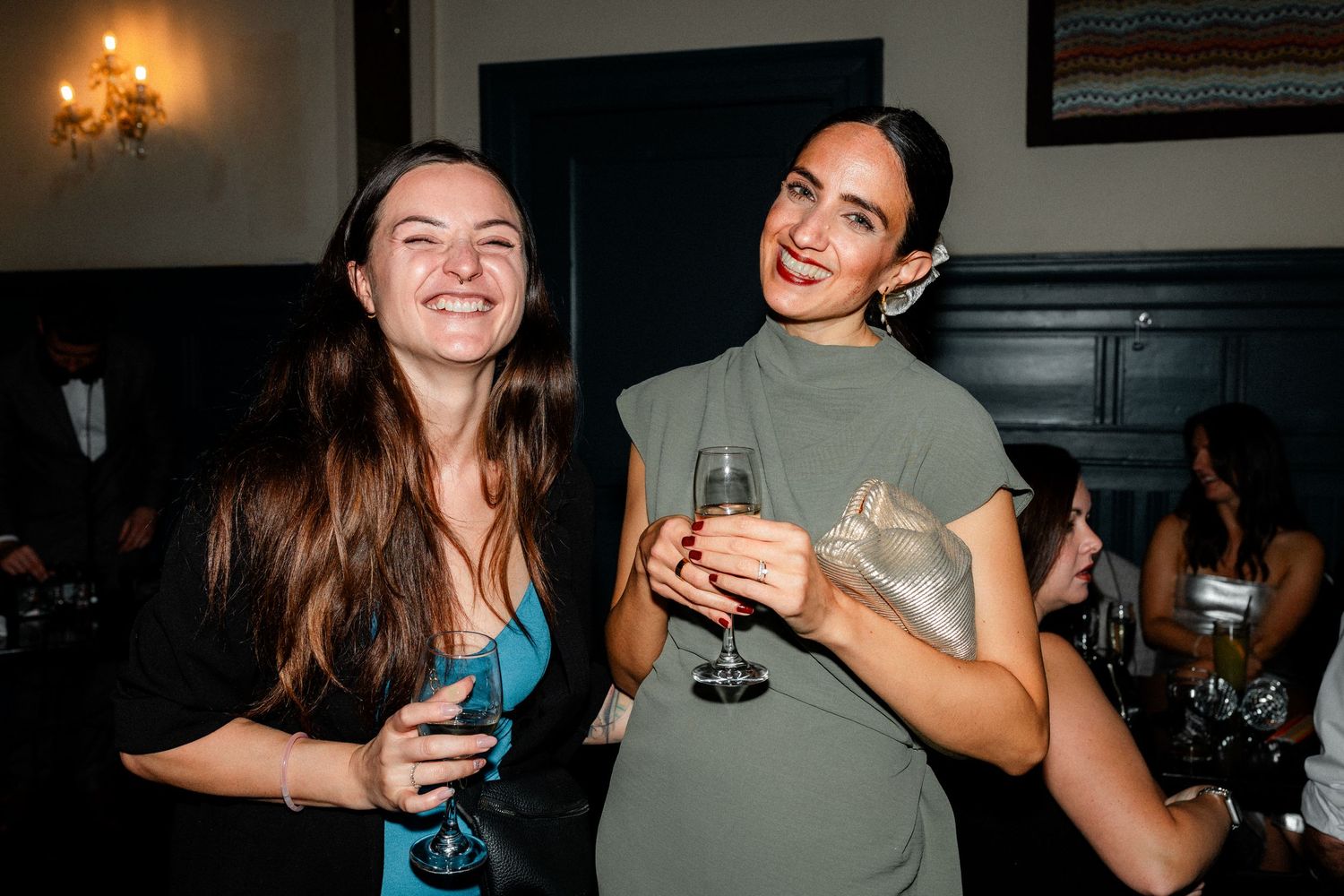 Party guests enjoying drinks and dancing at a lively wedding reception.