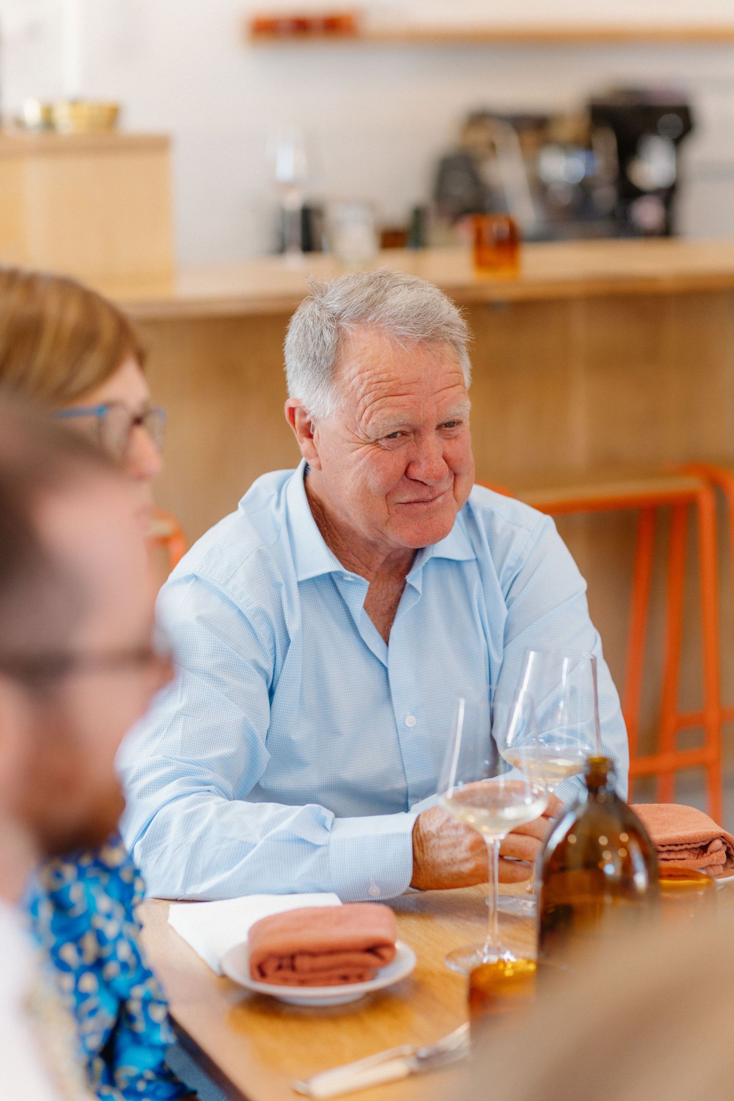 Two people dining at a casual restaurant with wooden tables and chairs.