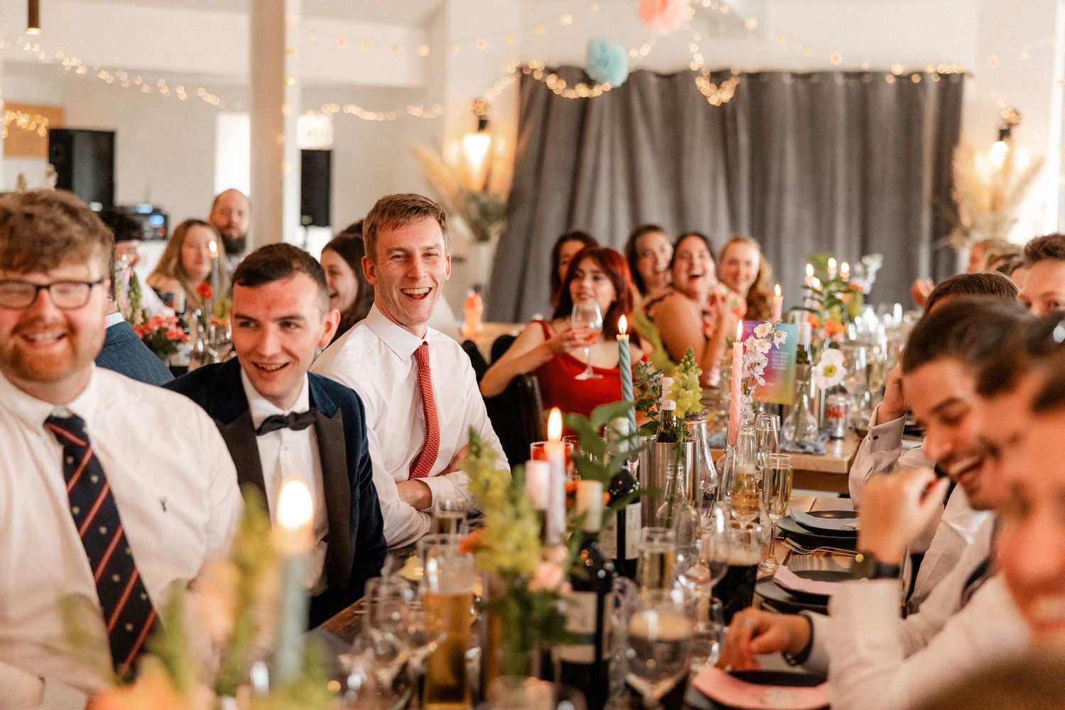 Wedding reception dining room filled with guests enjoying conversation and celebration.