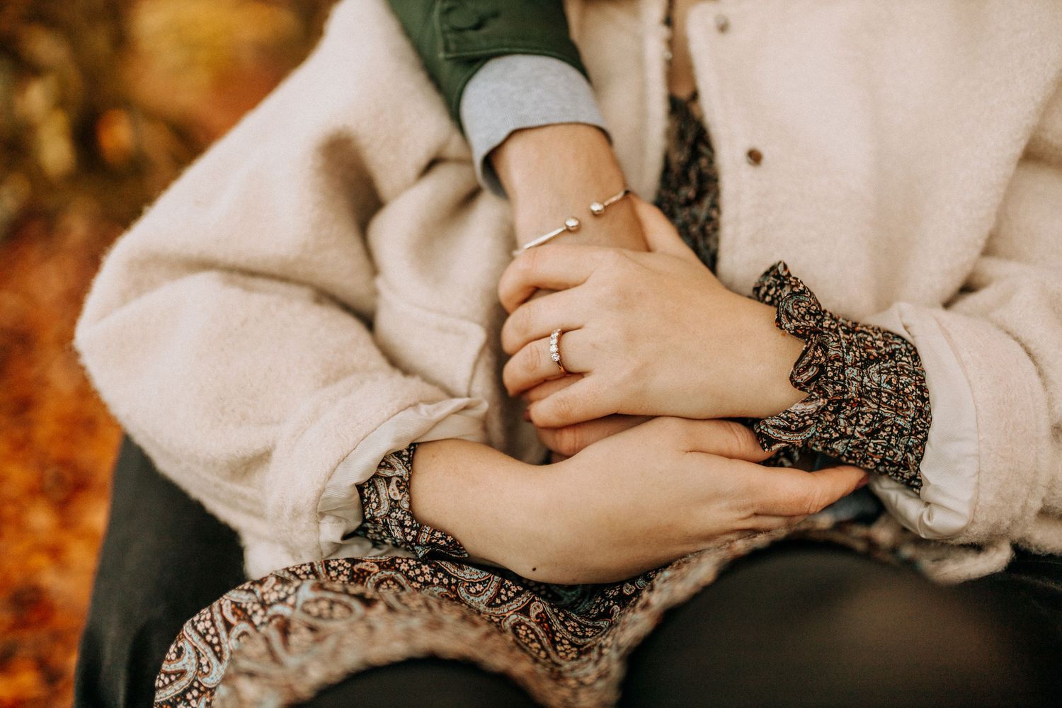 Cozy couple photos featuring cream sweaters and intimate poses against a fall backdrop.