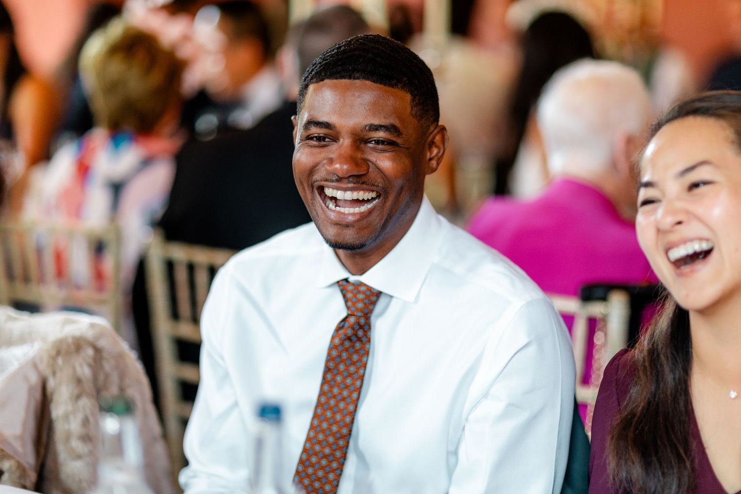 Wedding reception guests sharing joyful moments during dinner service.