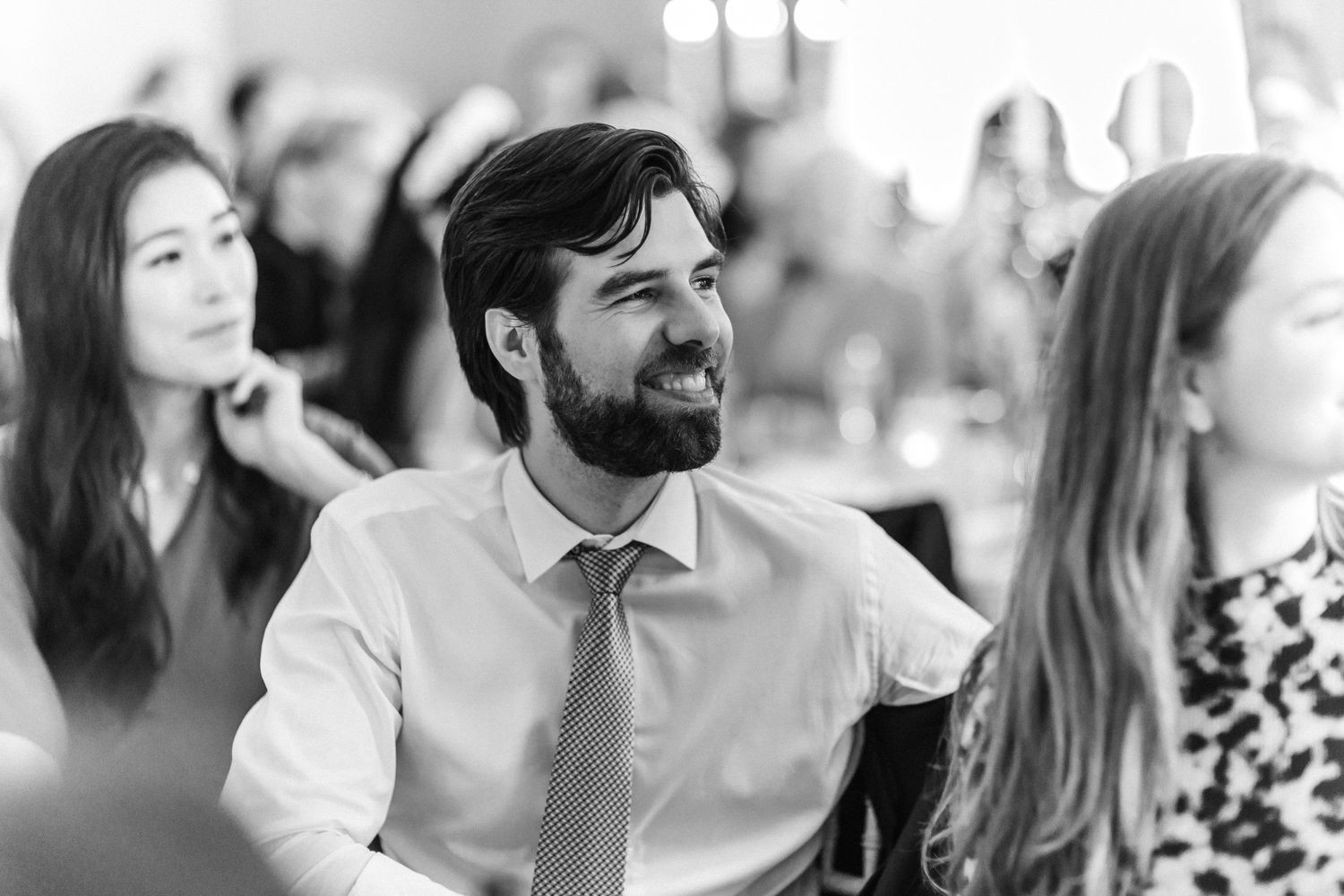 Wedding reception guests engaged in lively conversation at decorated dining tables.